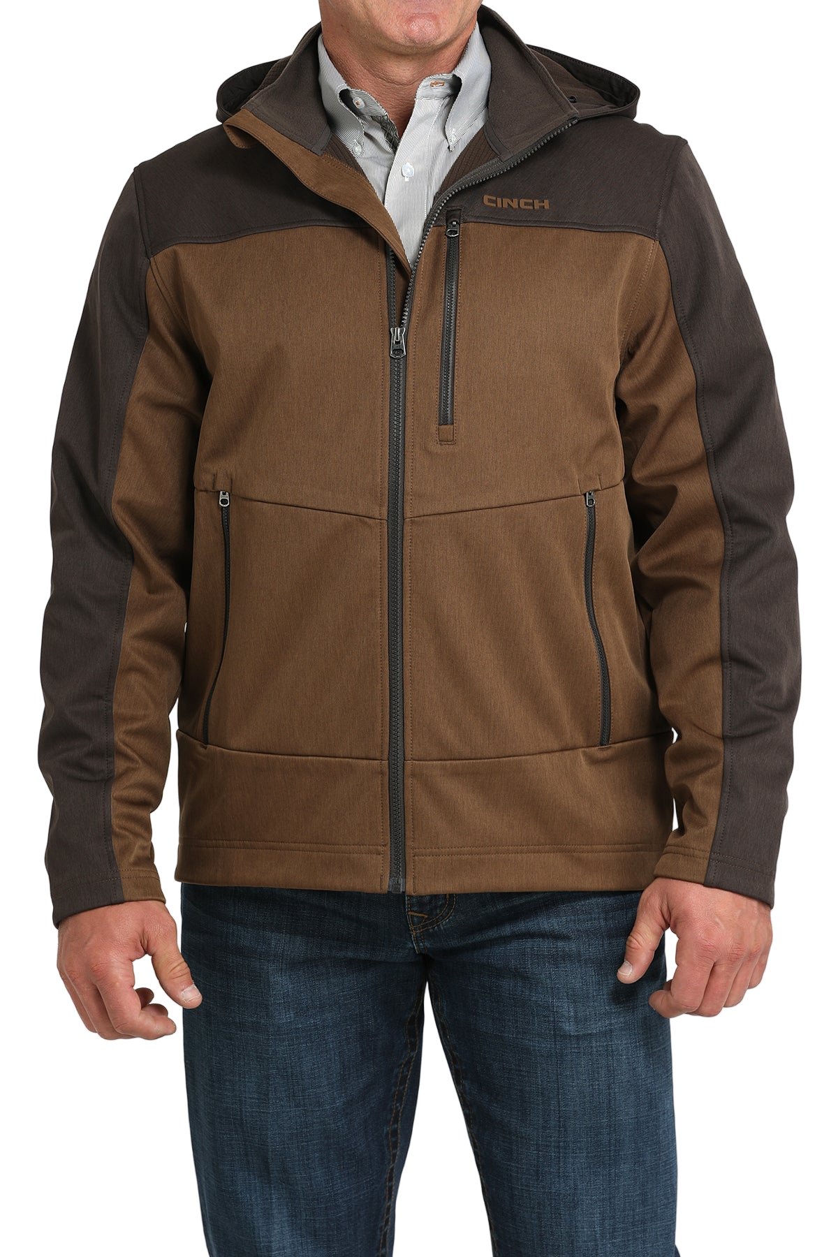 Man wearing a two-tone brown hooded softshell jacket paired with blue jeans