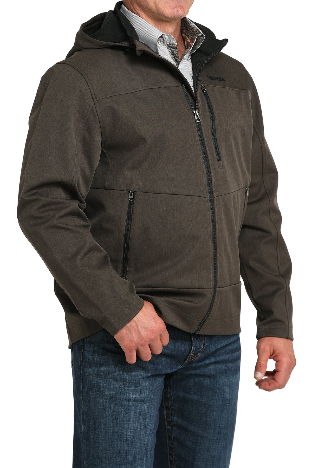 Man wearing a brown hooded softshell jacket paired with blue jeans