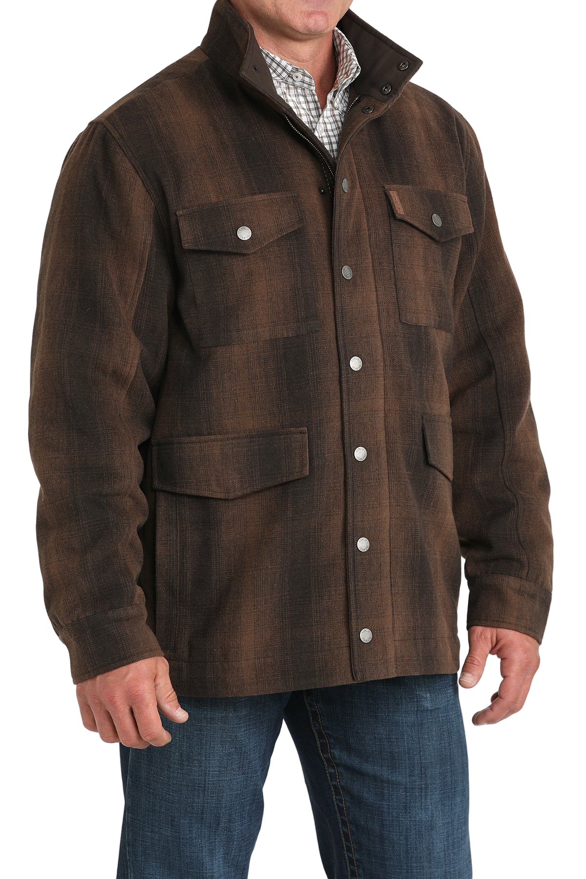 Man wearing a brown button-front jacket with multiple flap pockets, paired with blue jeans