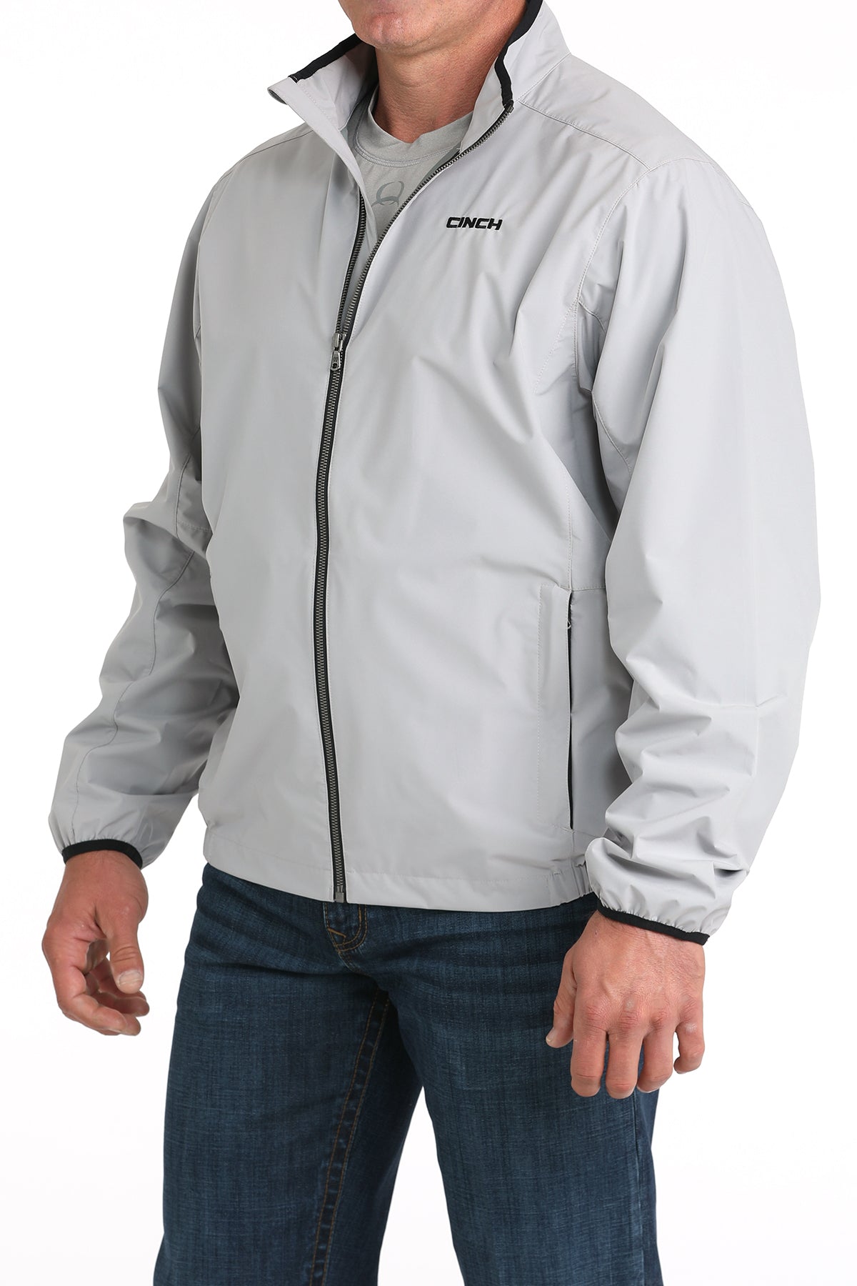 Person wearing a light gray jacket with a brand logo on a white background