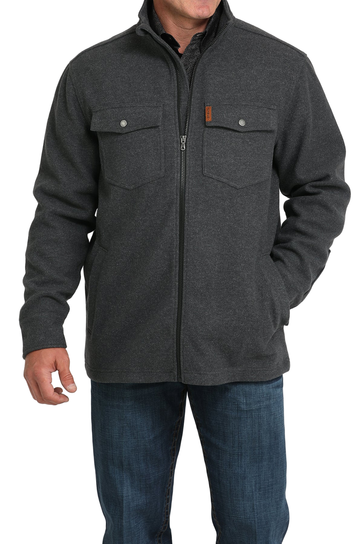 Man wearing a dark gray zip-front jacket with flap chest pockets, paired with blue jeans