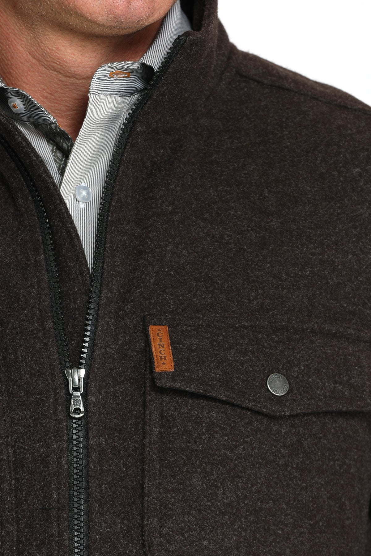 Close-up of a man wearing a brown jacket with a zipper and a chest pocket