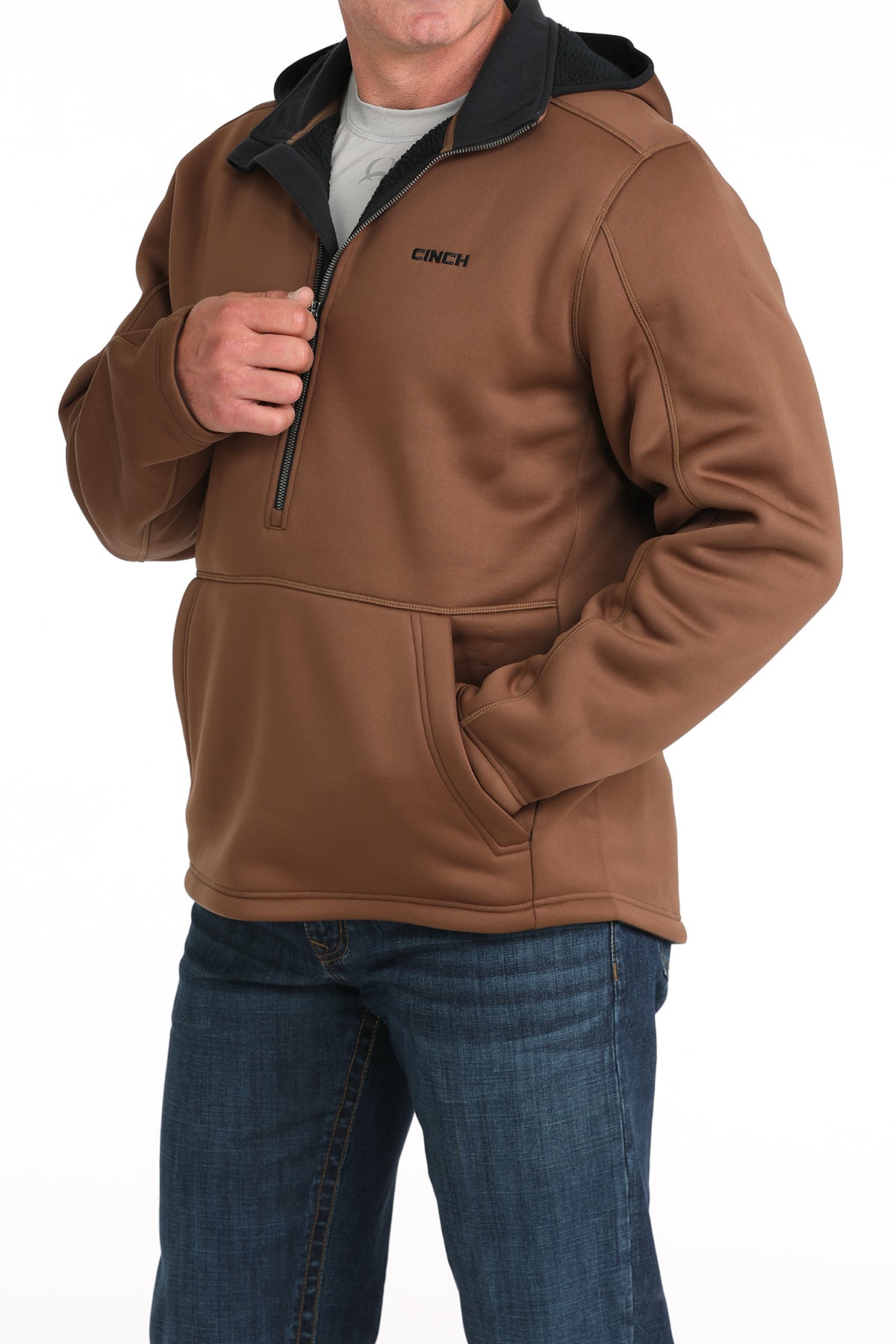 Man wearing a brown sherpa hoodie and jeans