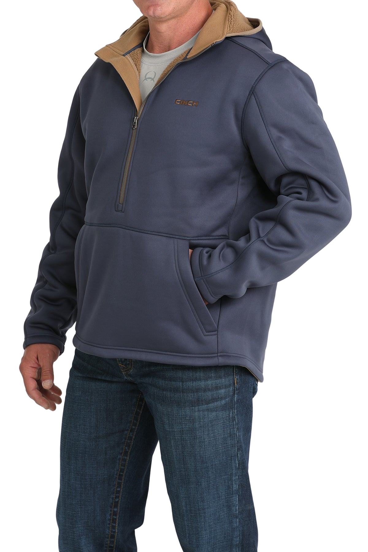 Man wearing a blue quarter-zip pullover with a tan inner collar and a front kangaroo pocket, paired with blue jeans