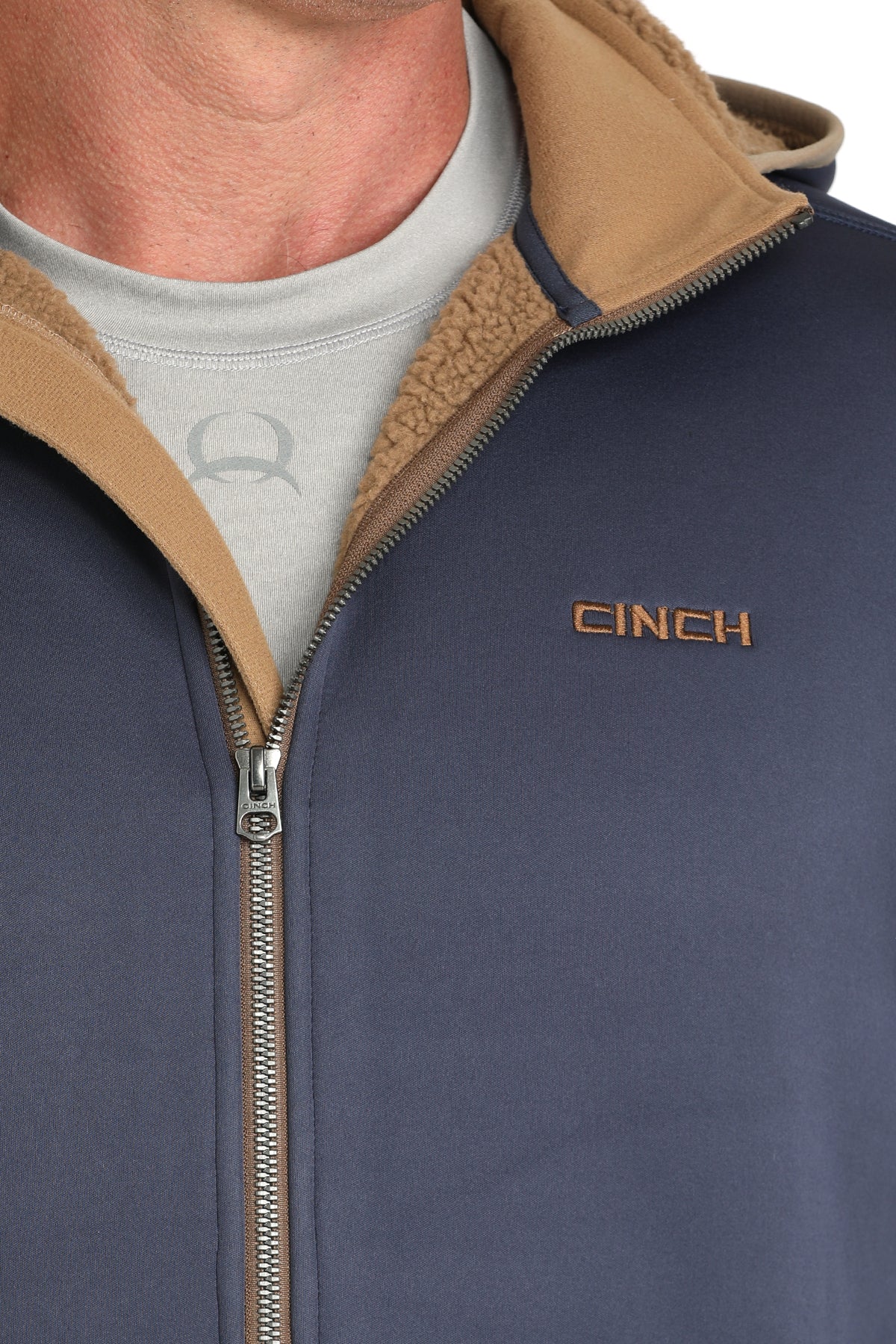 Close-up of a man wearing a blue sherpa hoodie with a zipper and small 'CINCH' logo