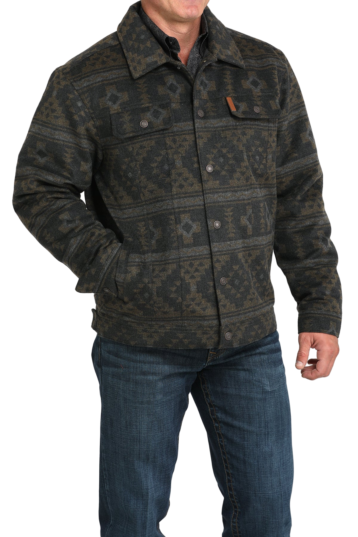 Man wearing a patterned dark green and black jacket with front buttons and chest pockets, paired with blue jeans