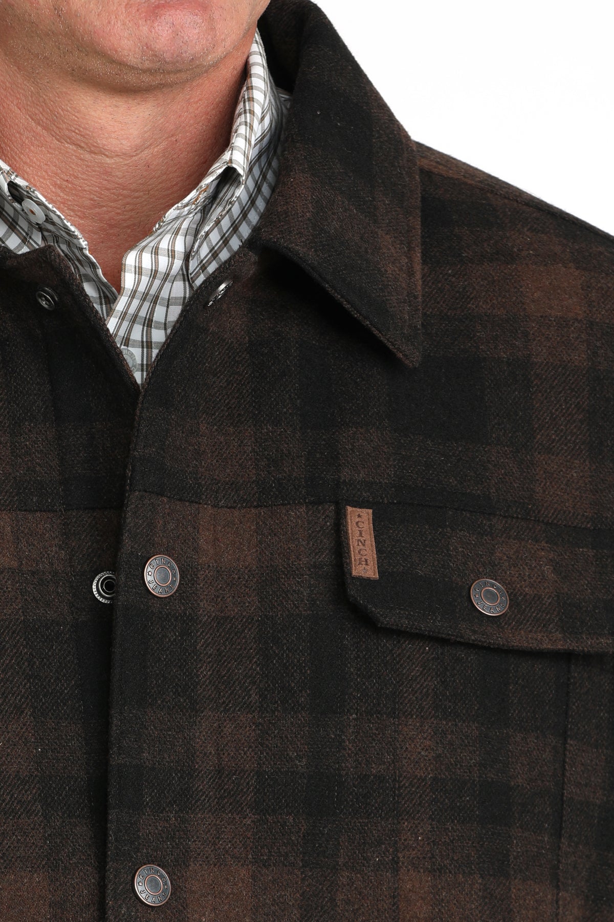 Close-up of a man wearing a brown patterned jacket with a chest pocket