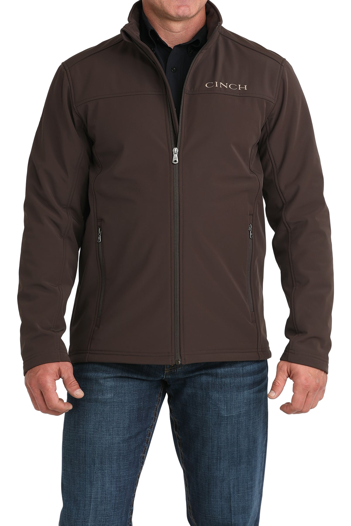 Man wearing a brown CINCH jacket with a full front zipper, paired with a black shirt and blue jeans