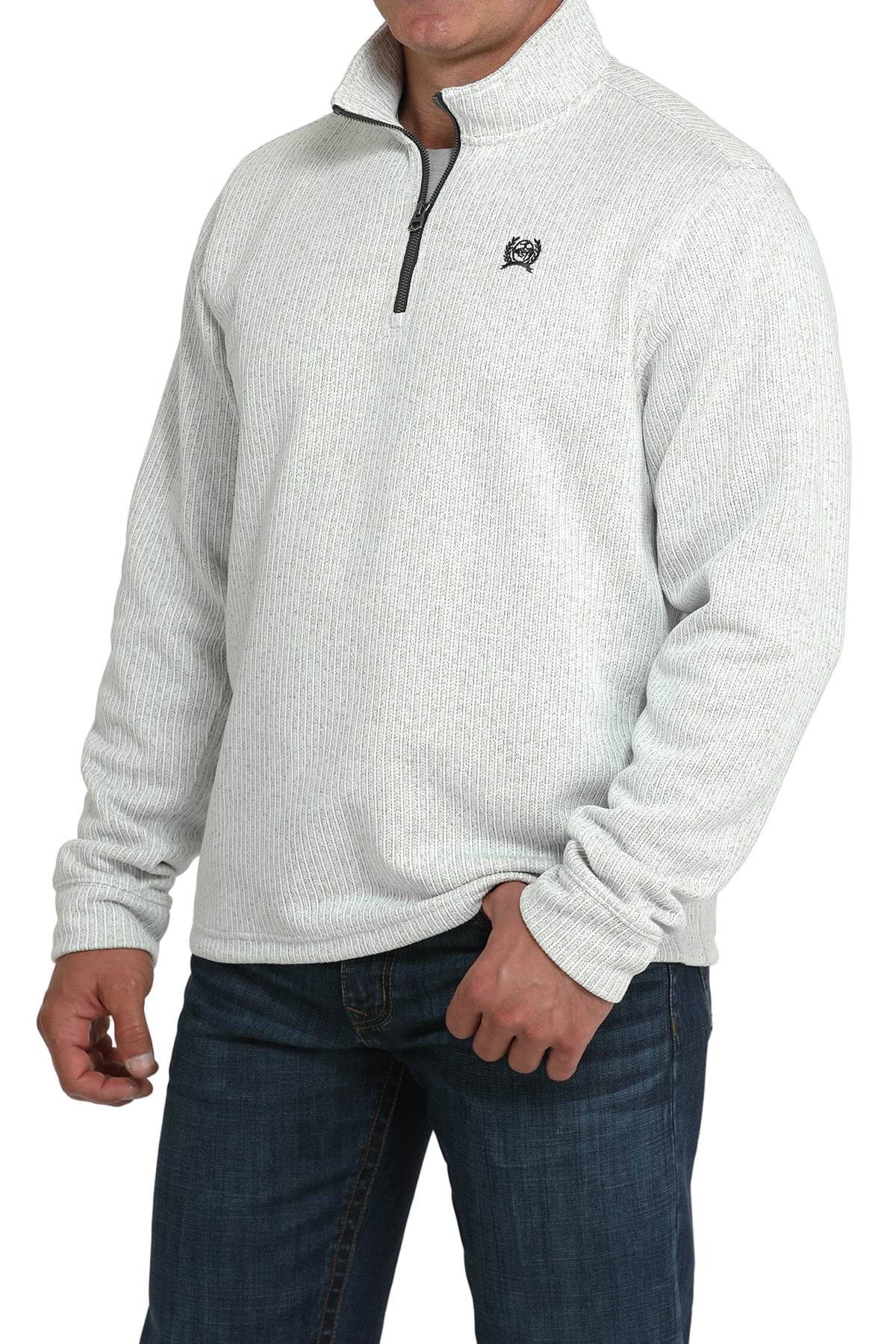 Man wearing a light gray textured quarter-zip pullover with dark jeans