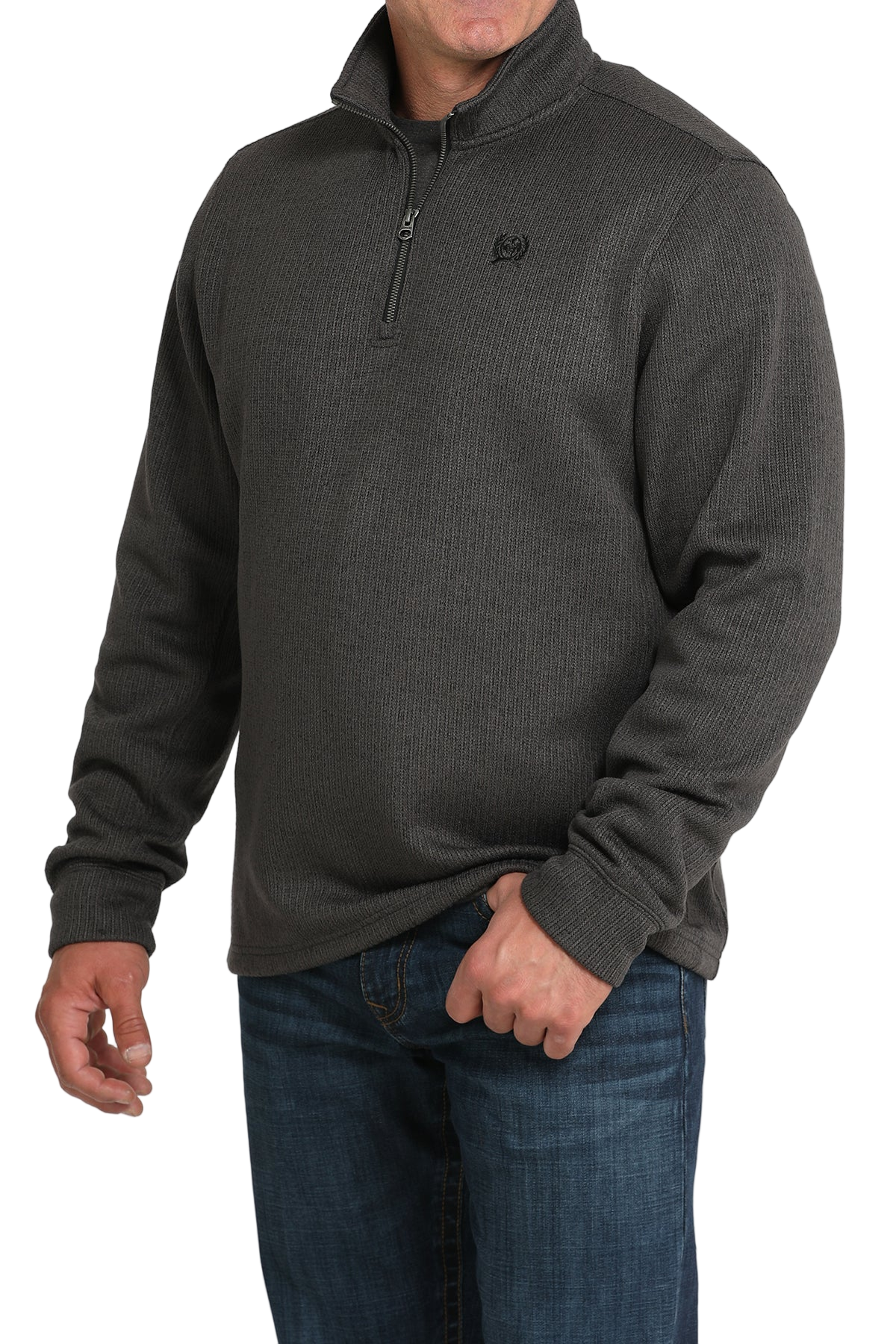 Man wearing a gray quarter-zip sweater and blue jeans on a white background