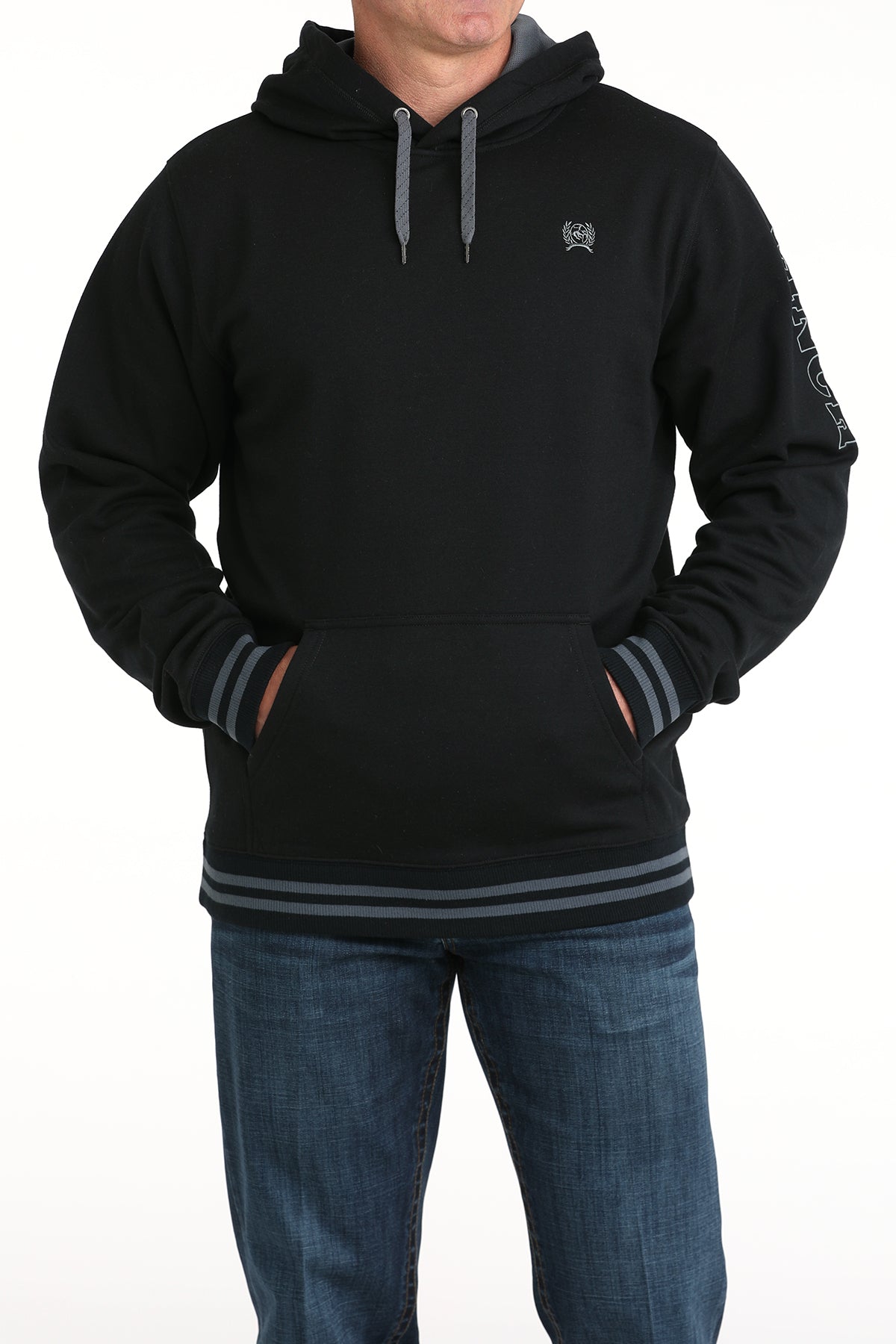 Person wearing a black hoodie with a small logo on a white background