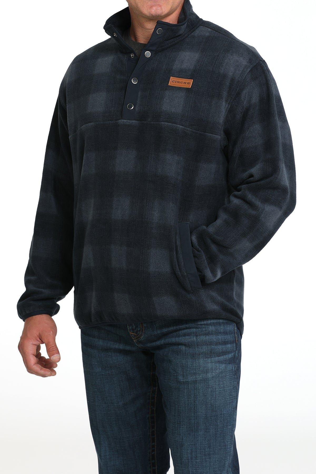 Man wearing a blue checkered fleece pullover and jeans