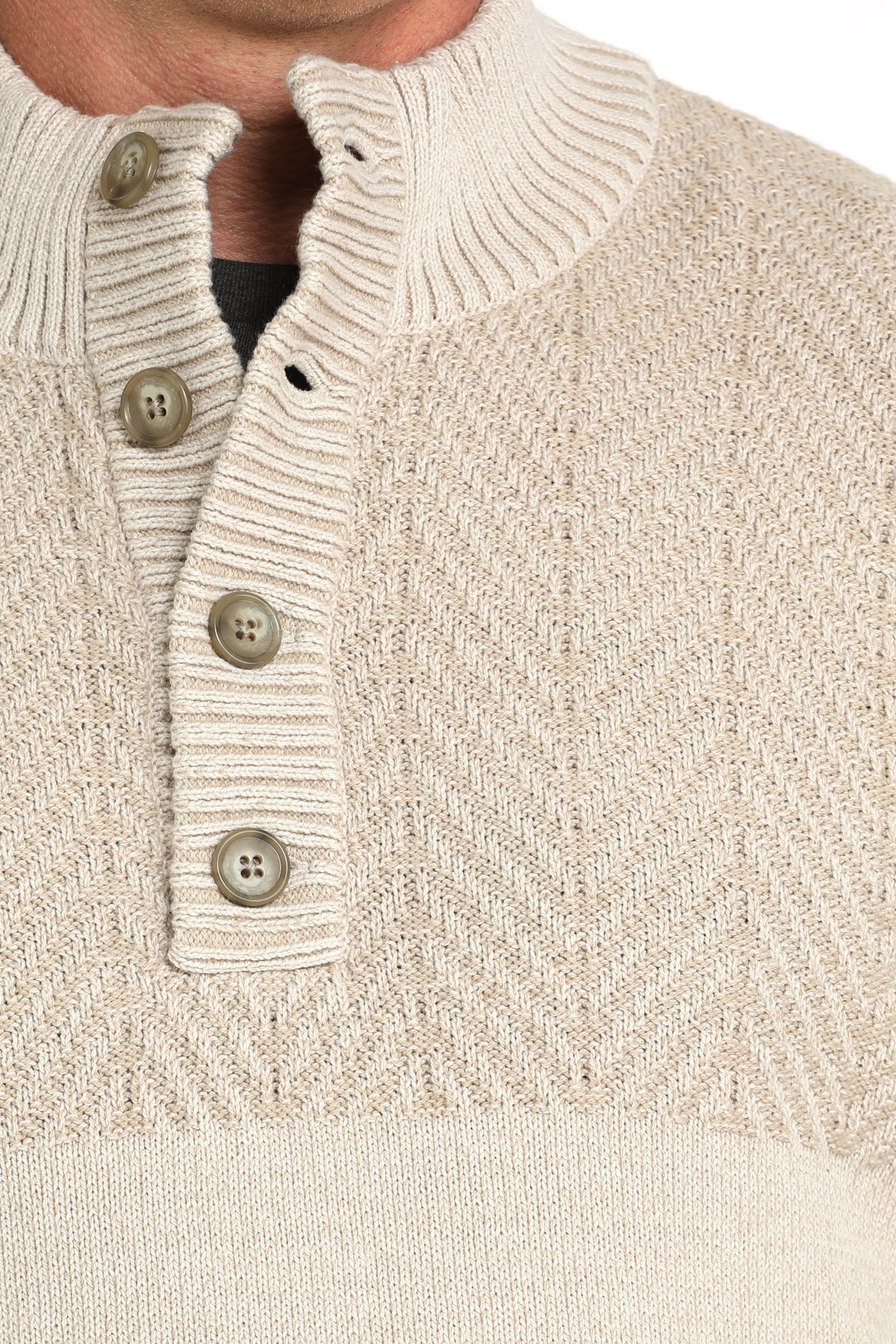 Close-up of a man wearing a white pullover sweater with buttons
