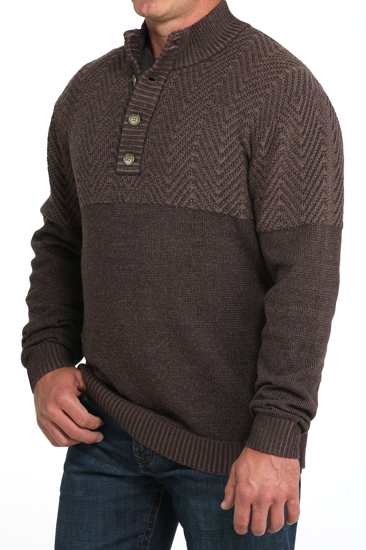 Man wearing a brown pullover sweater and jeans