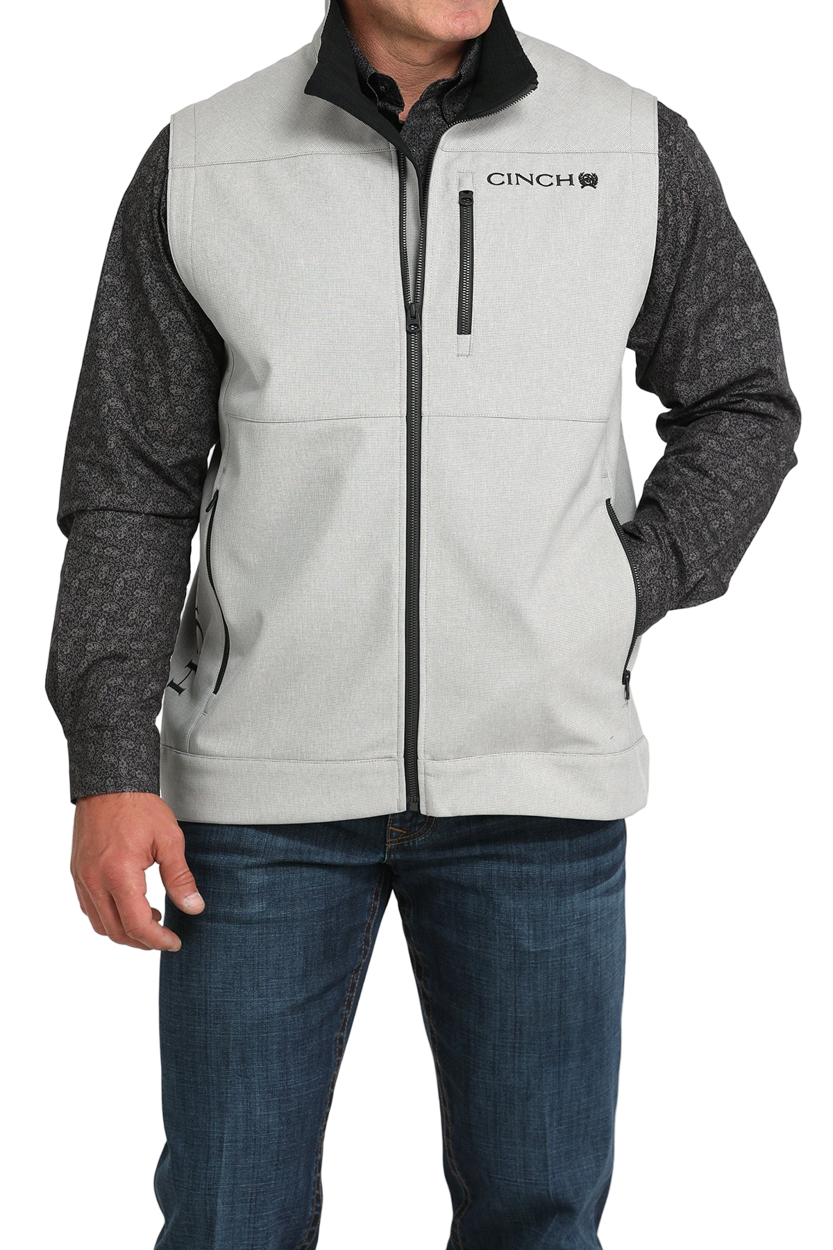 Man wearing a light gray zip-up vest over a gray long-sleeve shirt and jeans