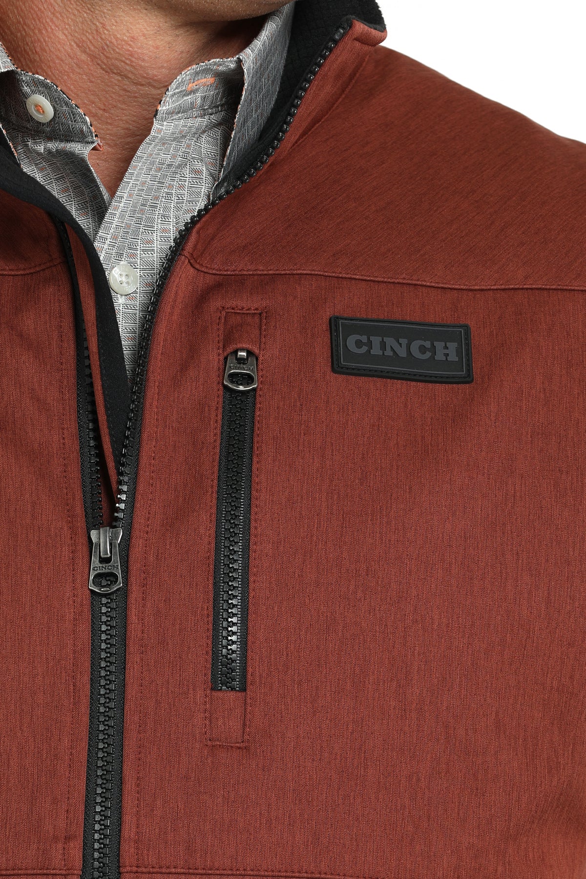 Close-up of a man wearing a red vest with a cinch logo