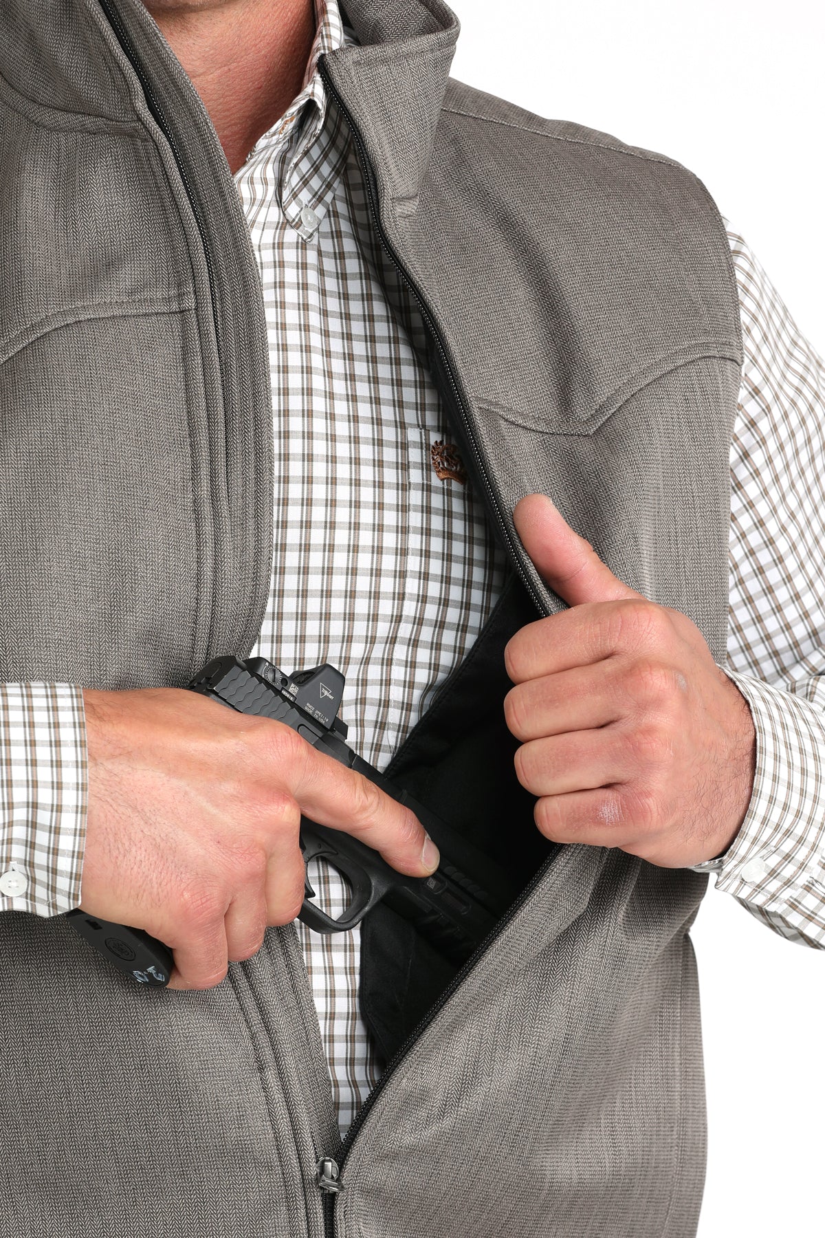 Close-up of a man wearing a brown concealed carry vest with an undershirt and a firearm