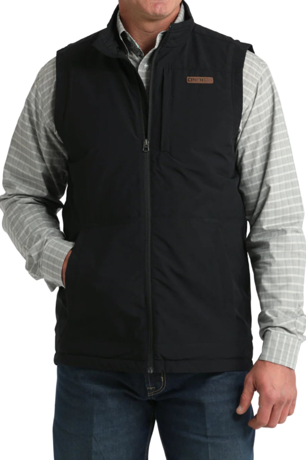 Man wearing a black vest over a plaid shirt on a white background