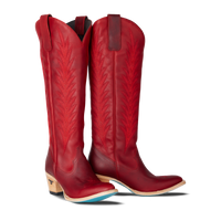 Tall red cowboy boots with decorative stitching and stacked wooden heels, on a transparent background