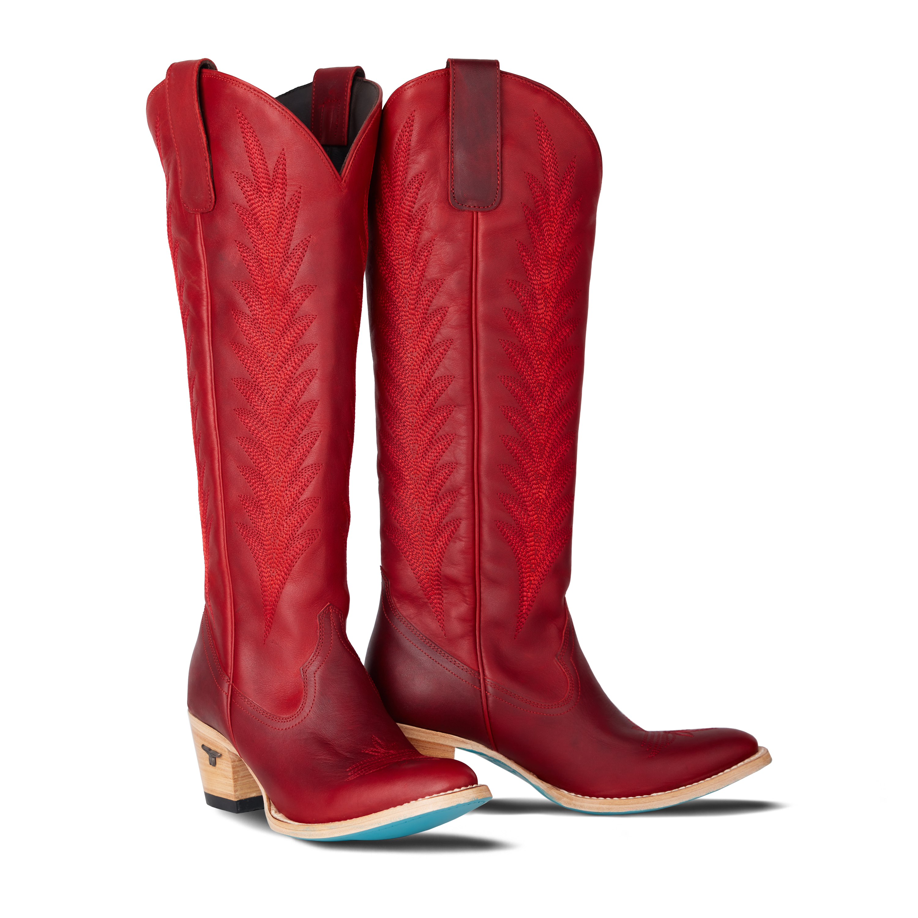 Tall red cowboy boots with decorative stitching and stacked wooden heels, on a transparent background