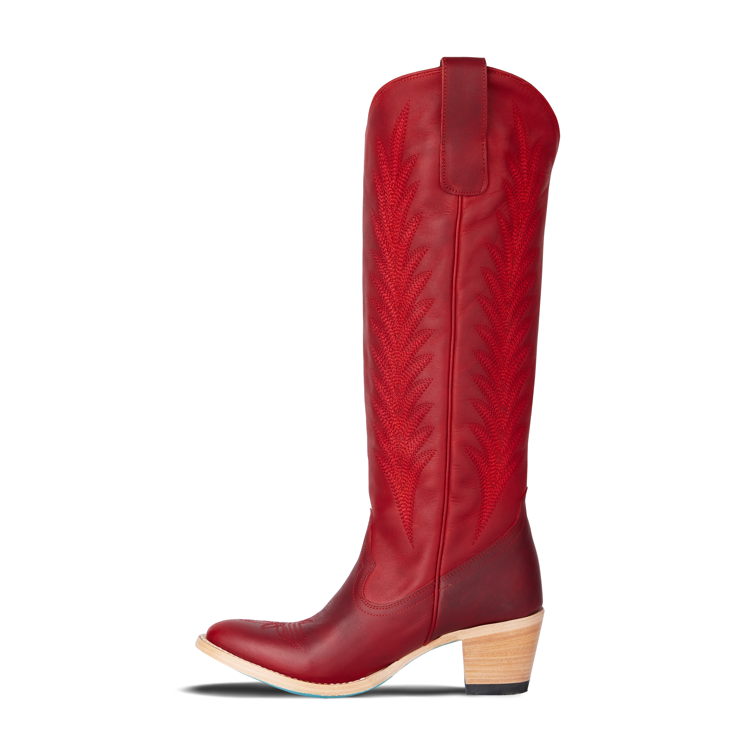 Side view of a tall red cowboy boot with decorative stitching and a stacked wooden heel, on a transparent background
