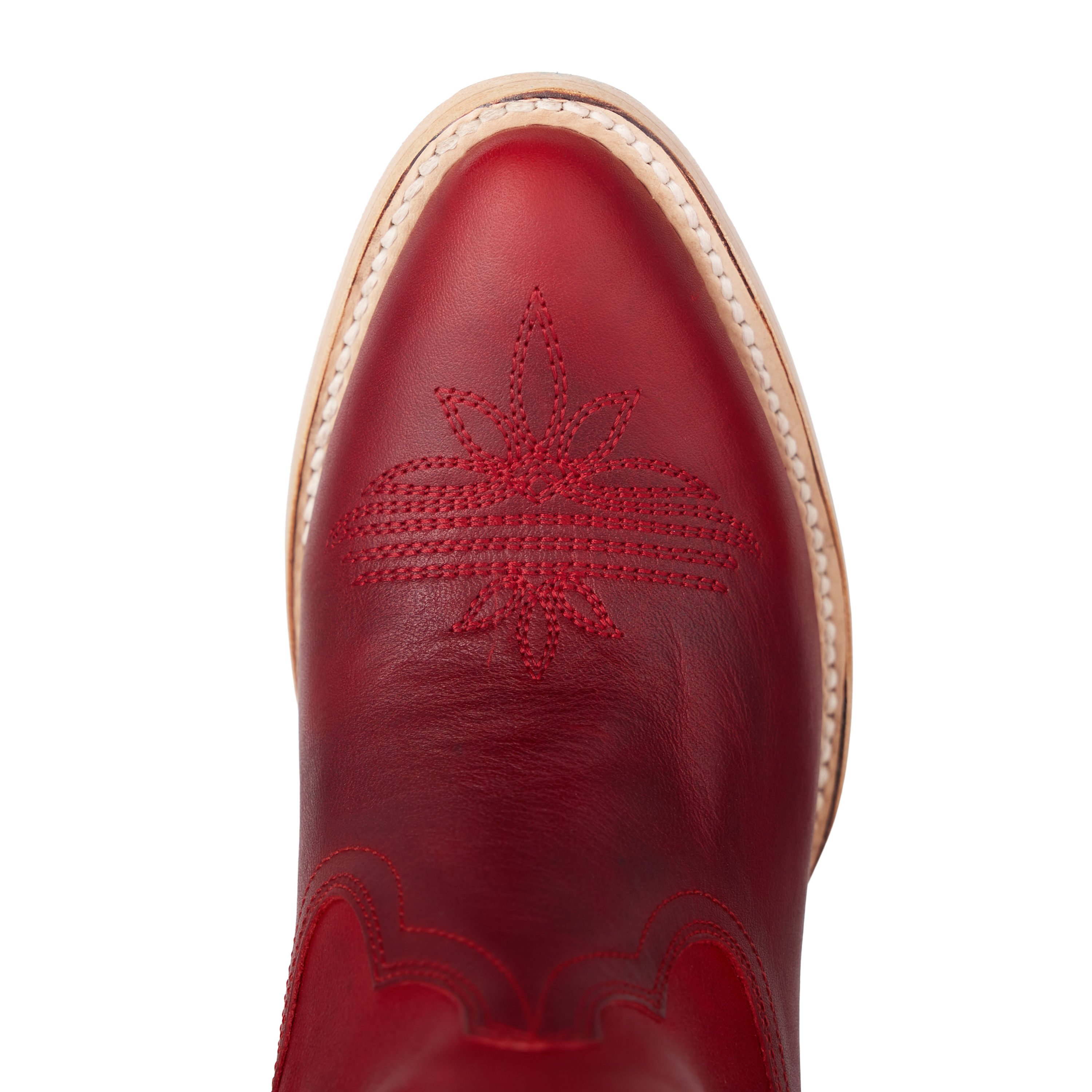 Close-up of a red cowboy boot toe with decorative stitching in a starburst pattern and a light-colored welt