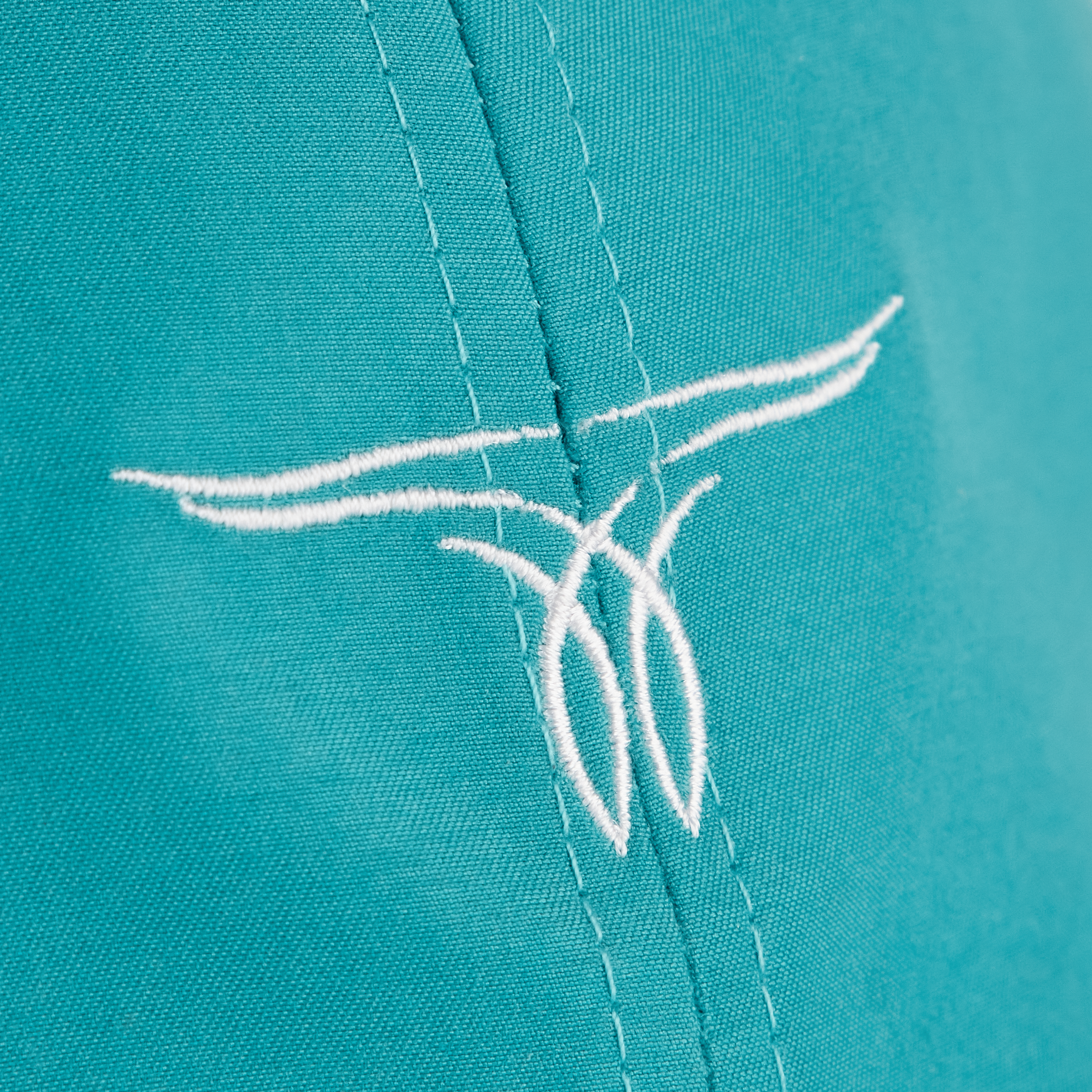 A close-up of a turquoise hat with a white embroidered logo