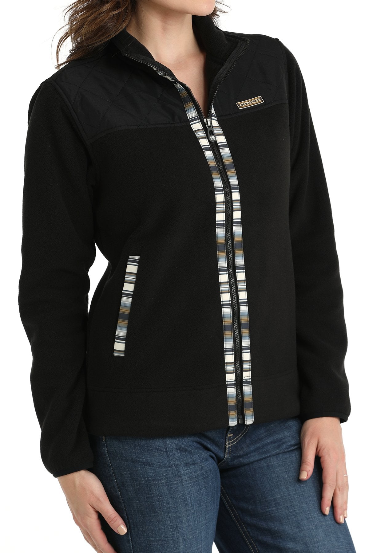 Woman wearing a black Cinch jacket with western trim accents and jeans