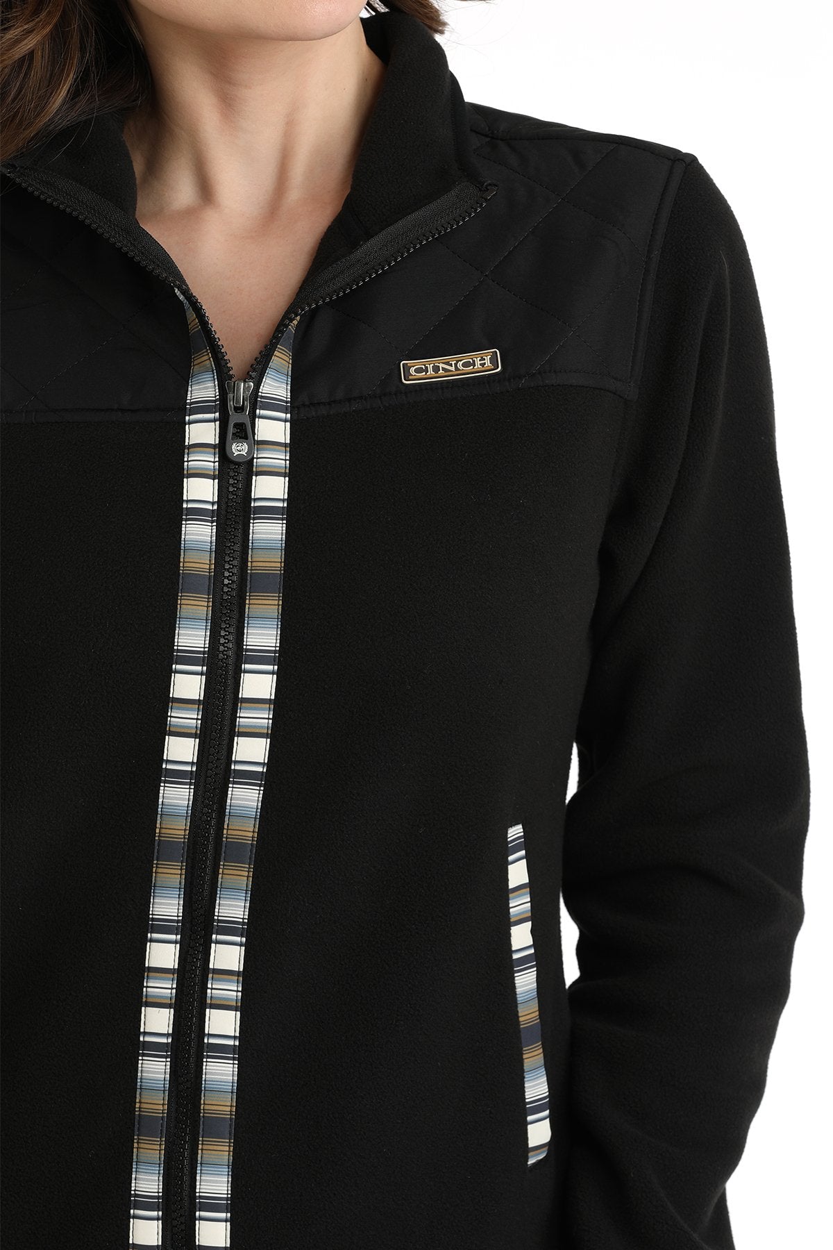 Close-up of a woman wearing a black Cinch jacket with western trim accents