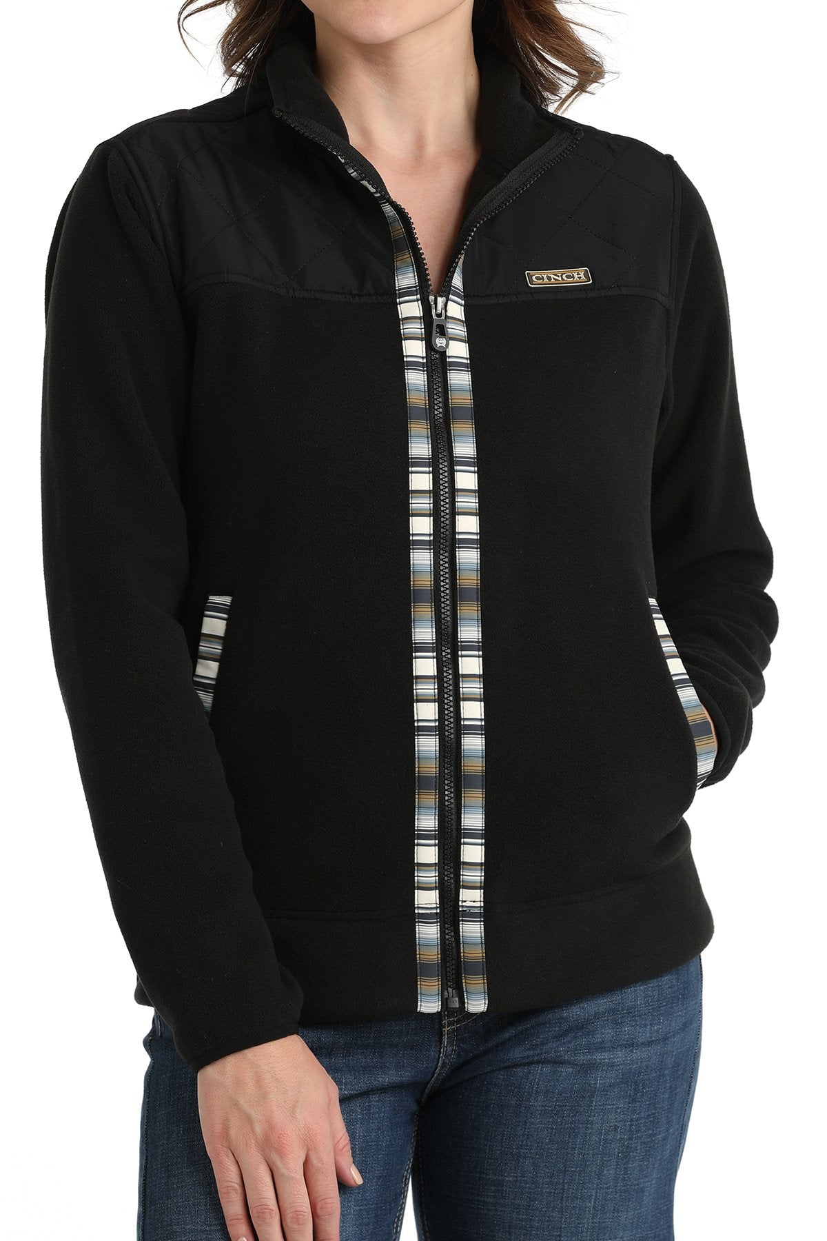 Woman wearing a black Cinch jacket with western trim accents and jeans