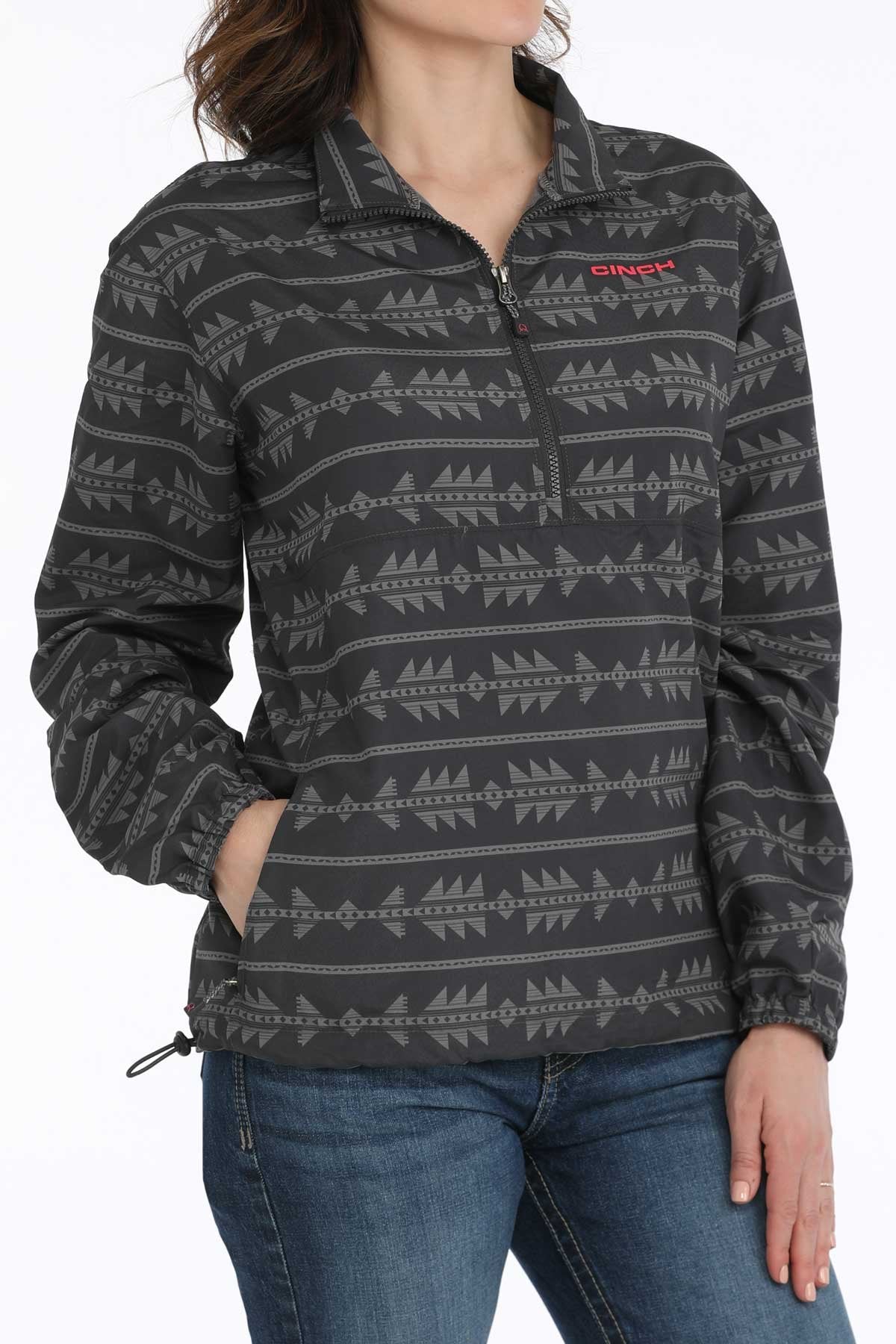 Person wearing a patterned pullover with a visible brand logo on a white background
