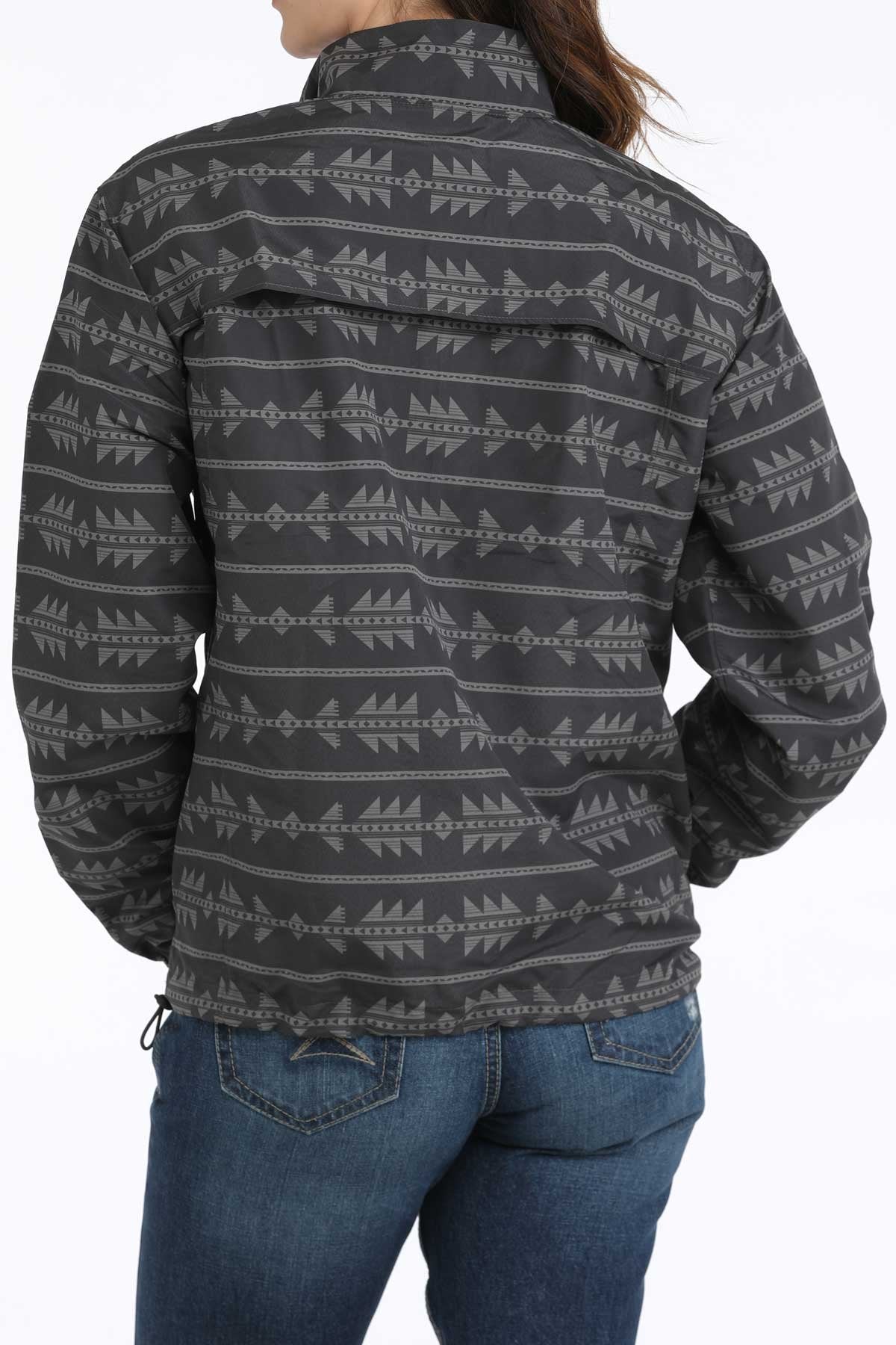 Person wearing a patterned shirt with blue jeans on a white background