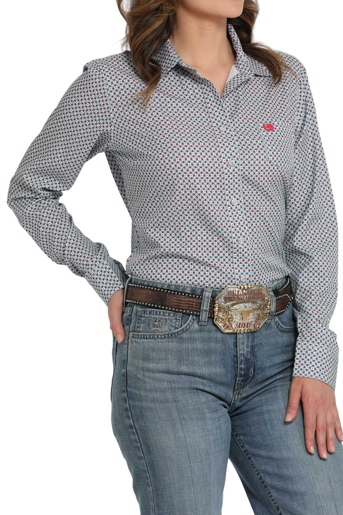 Woman wearing a light patterned long-sleeve button shirt paired with light-wash jeans and a brown belt with a large decorative buckle