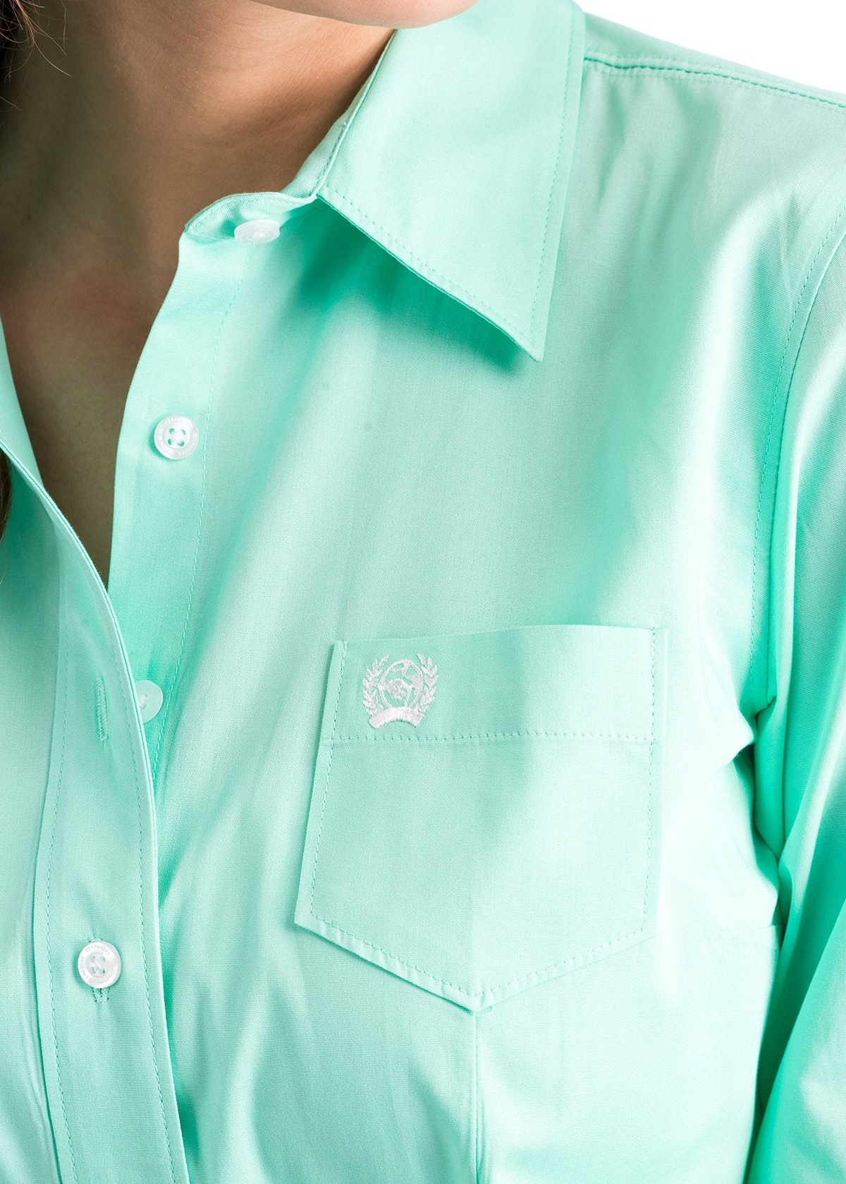 Close-up of a woman wearing a mint green button down shirt