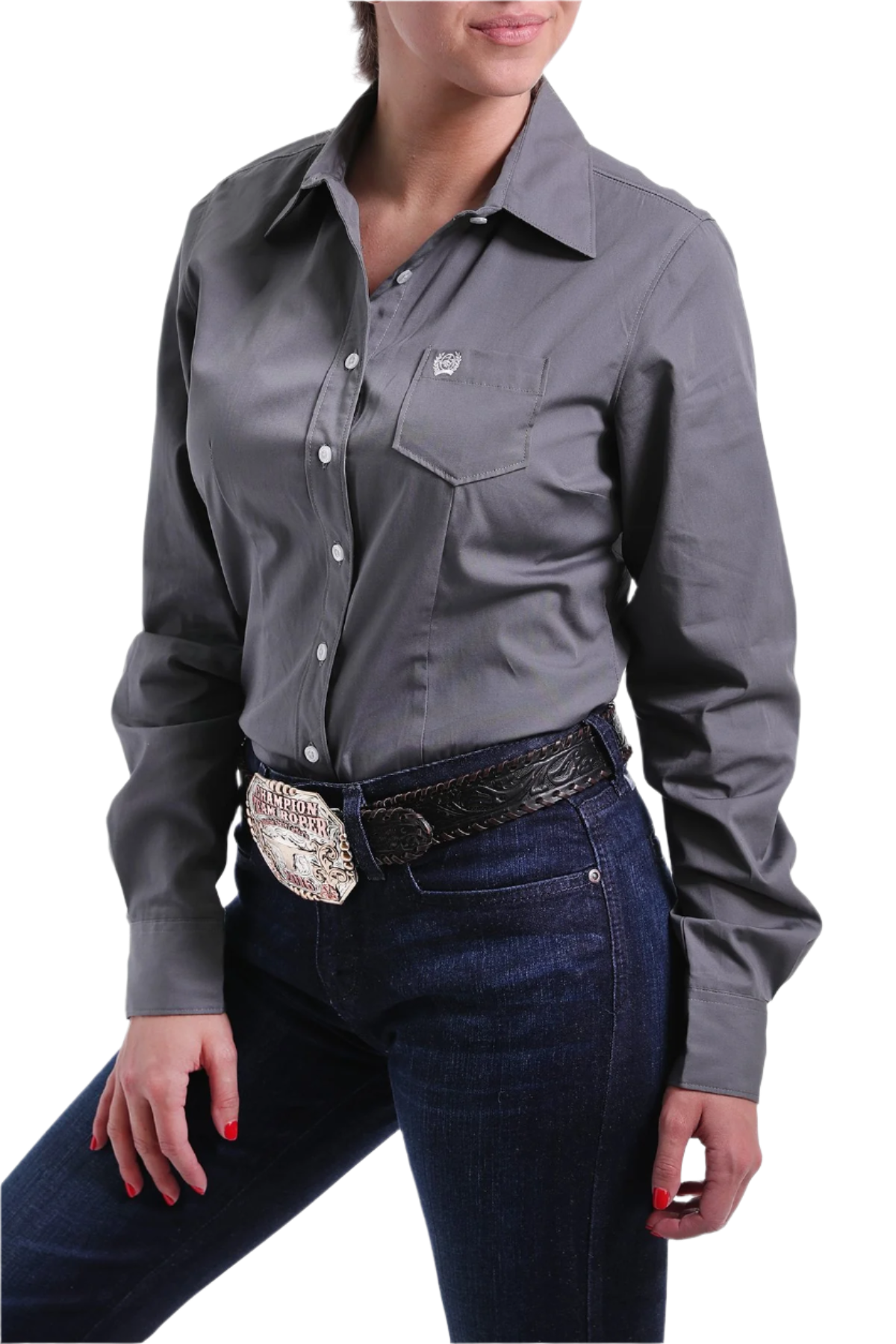 Woman wearing a gray button down shirt with jeans and a western belt