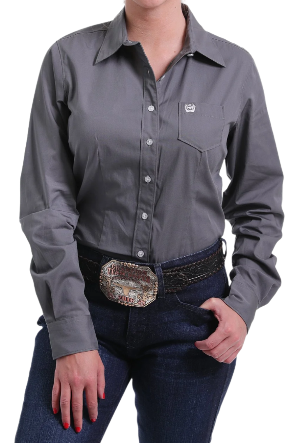 Woman wearing a gray button down shirt with jeans and a western belt