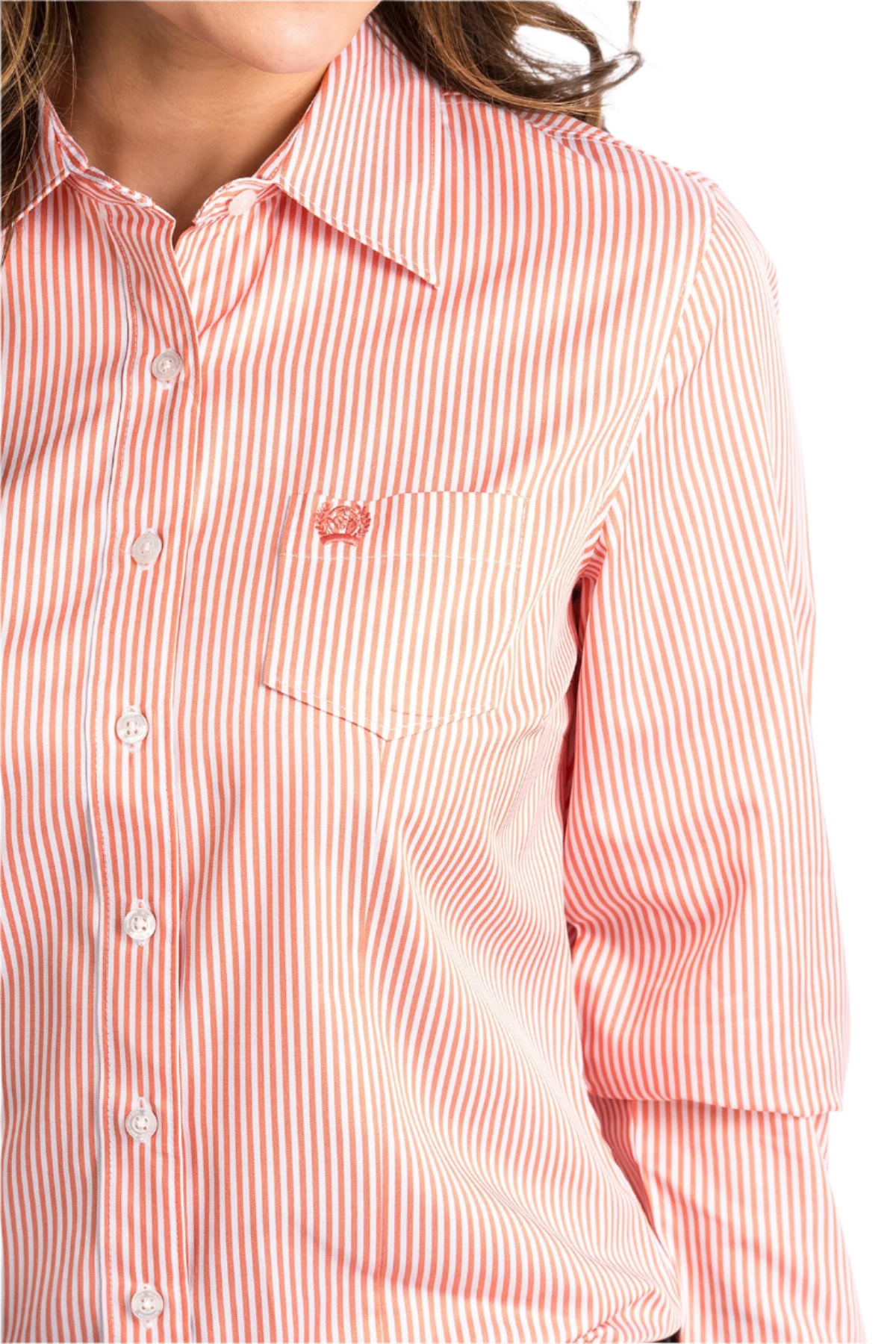 Close-up of a woman wearing a coral button down shirt