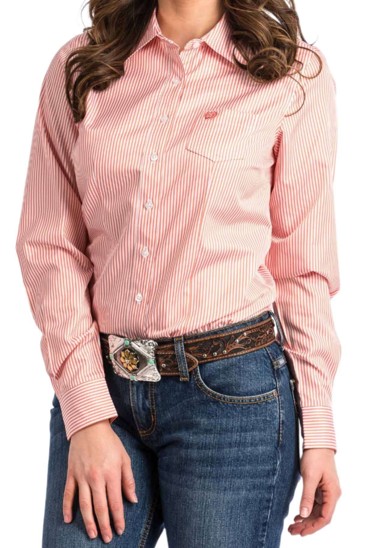 Woman wearing a coral button down shirt with jeans and a western belt