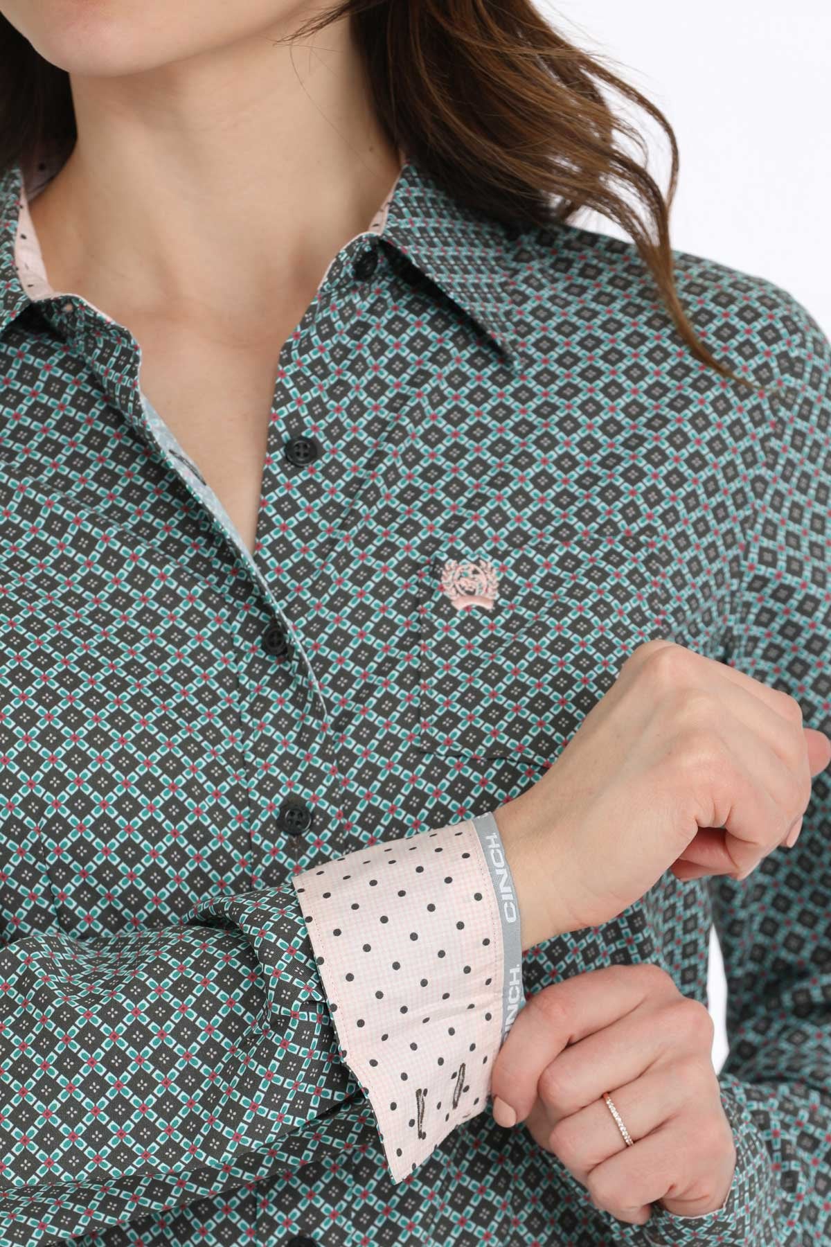 Close-up of a person wearing a patterned shirt with polka dot cuffs.