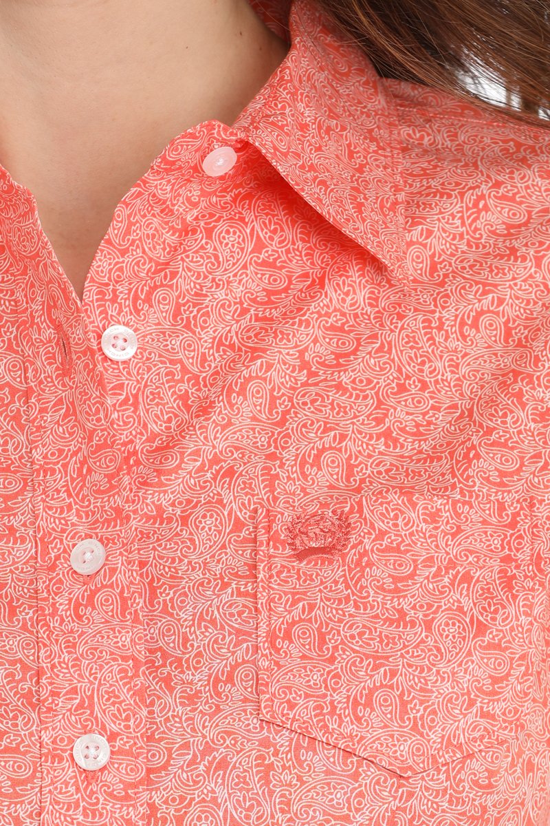 Close-up of a woman wearing a coral long sleeve button-down shirt