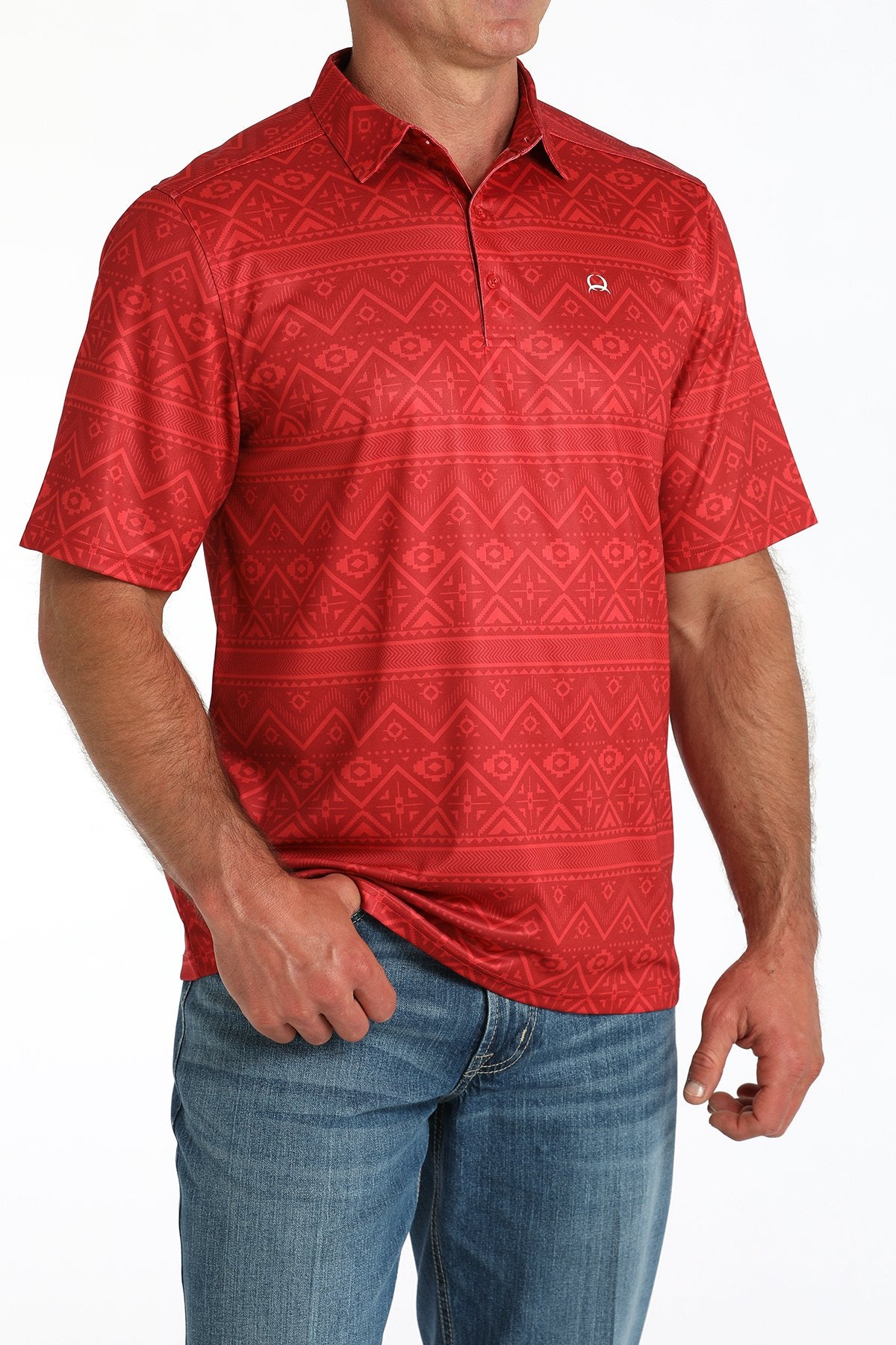Man wearing a red short-sleeve polo shirt with a subtle geometric pattern and blue jeans displayed on a white background.
