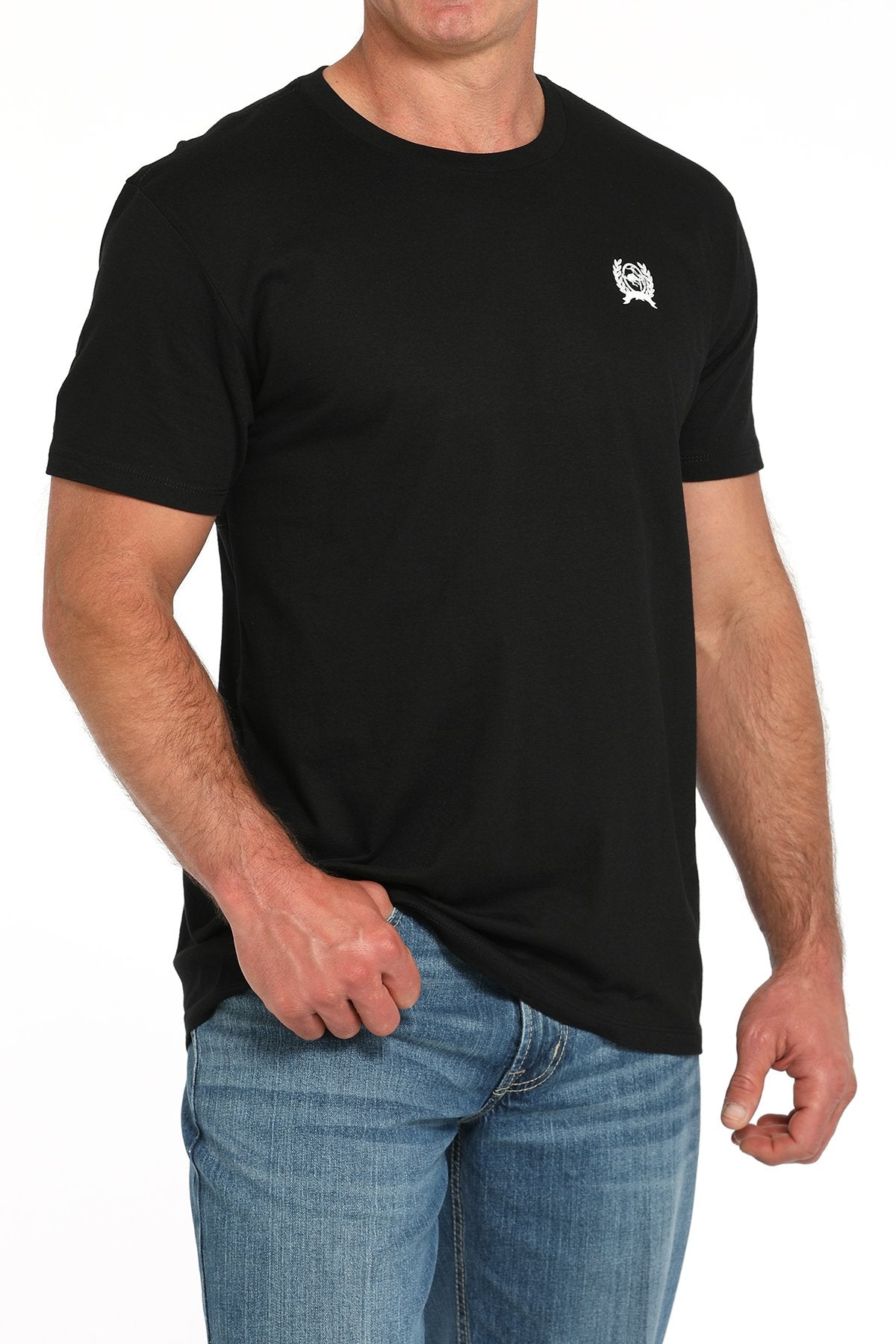 Front view of a man wearing a black short-sleeve t-shirt with a small white logo on the chest, paired with blue jeans displayed on a white background.