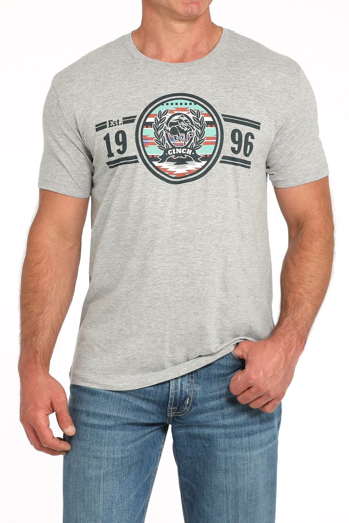 Front view of a man wearing a gray short-sleeve t-shirt with a circular CINCH graphic and '1996' text, paired with blue jeans displayed on a white background.
