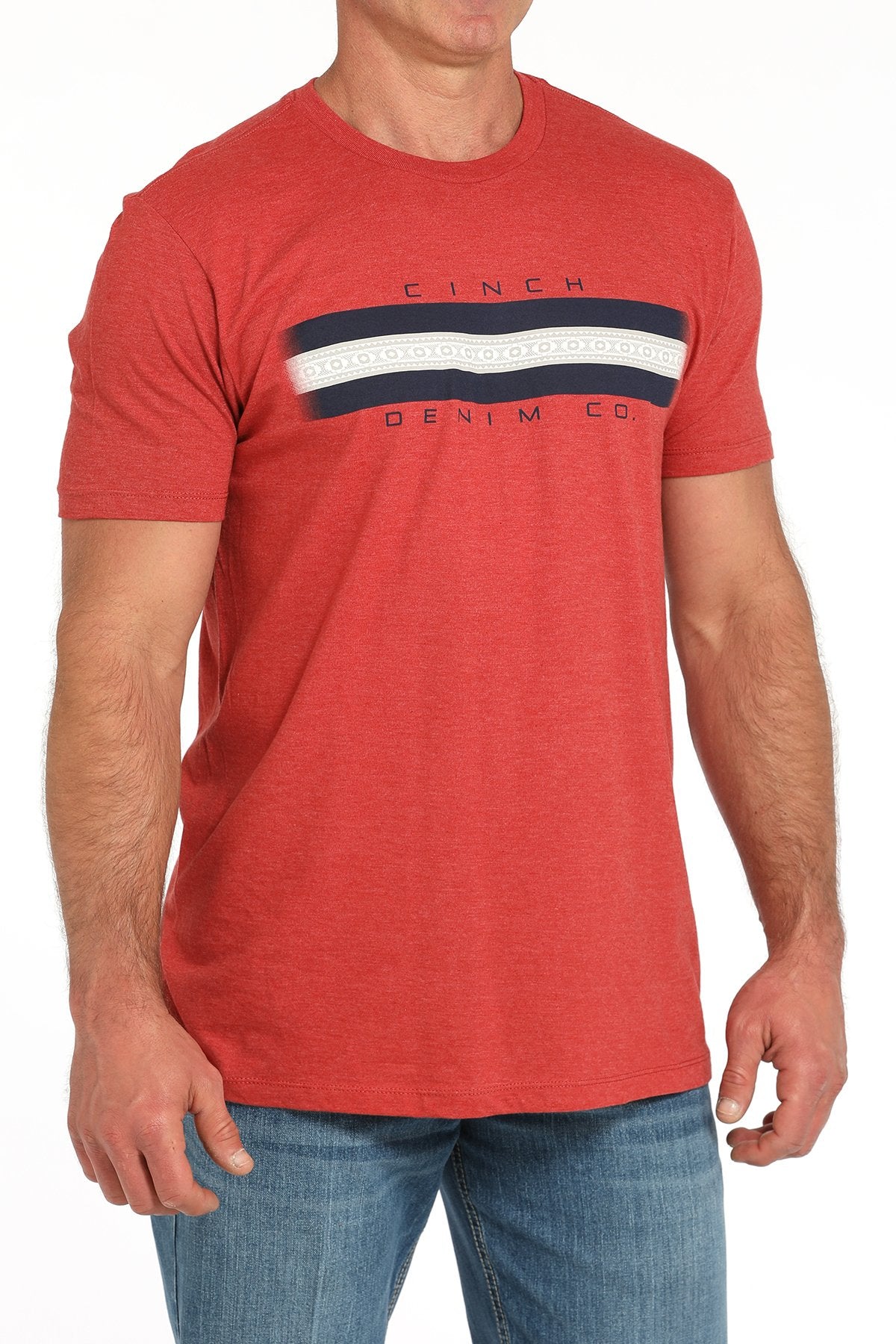Side angled view of a man wearing a red short-sleeve t-shirt with a horizontal navy and white stripe graphic across the chest, paired with blue jeans displayed on a white background.