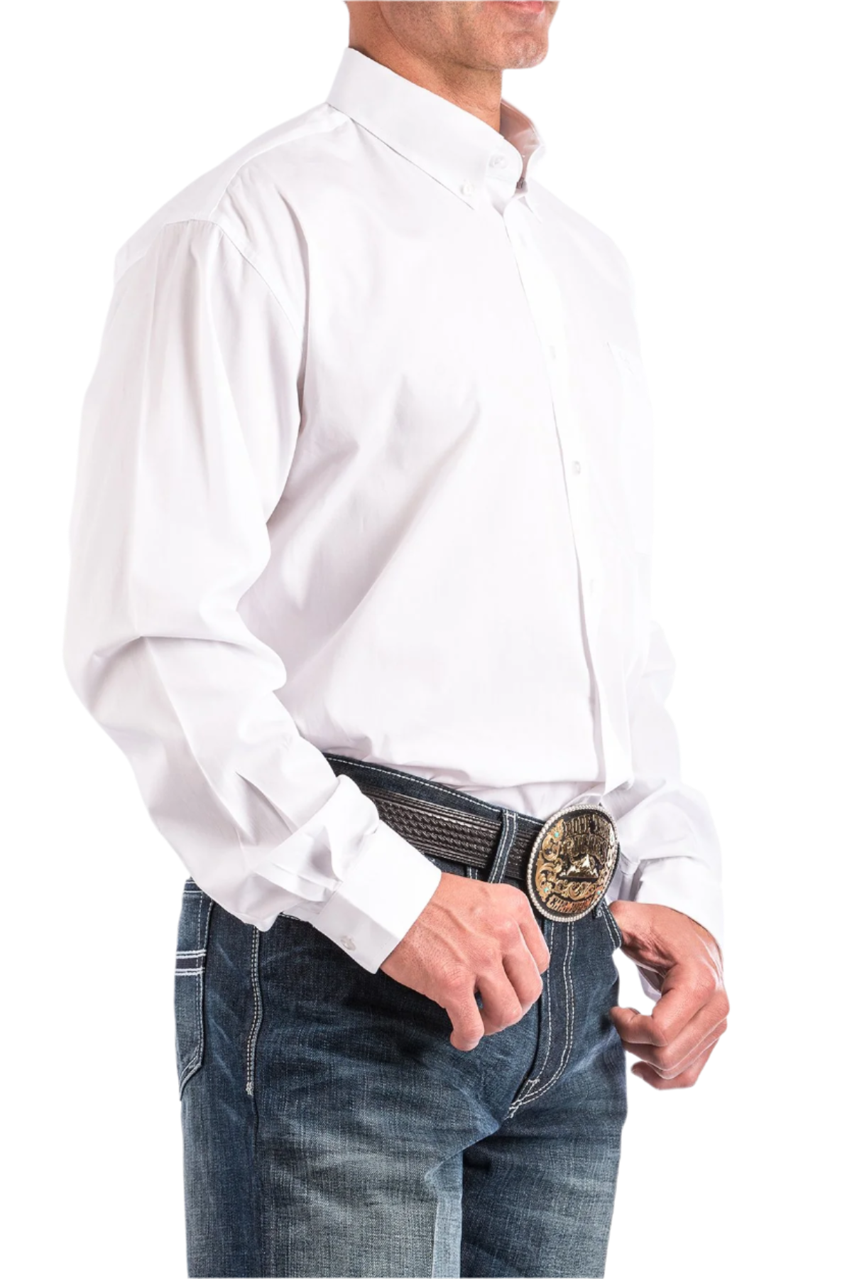A man wearing a white long-sleeve button-down shirt and blue jeans. The shirt is tucked into the jeans, and the man is wearing a belt with a decorative buckle.