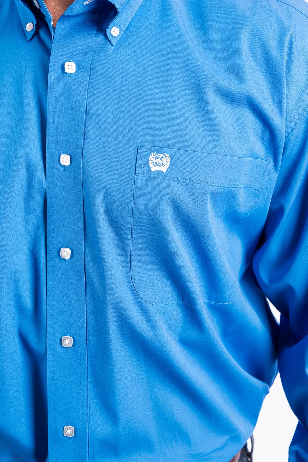 Close-up of a man wearing a blue button-up shirt on a white background