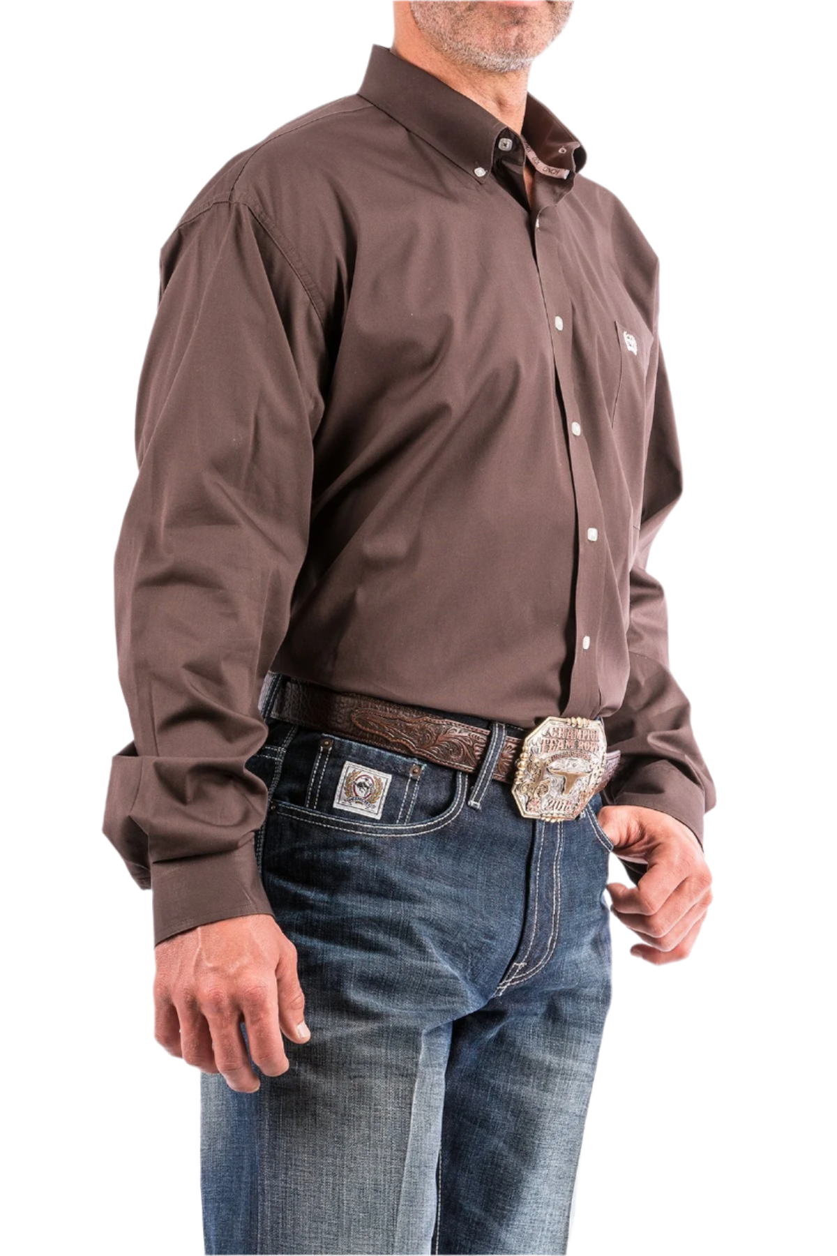A man wearing a brown long-sleeve button-down shirt and blue jeans, with a belt and buckle visible.