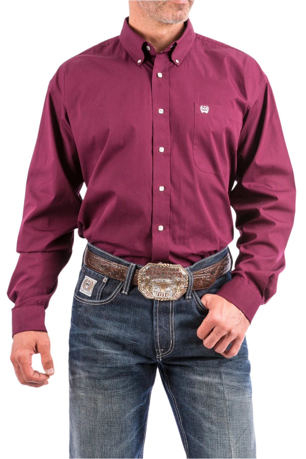 A man wearing a long sleeve burgundy solid color button-down shirt and blue jeans, with a belt and buckle visible.