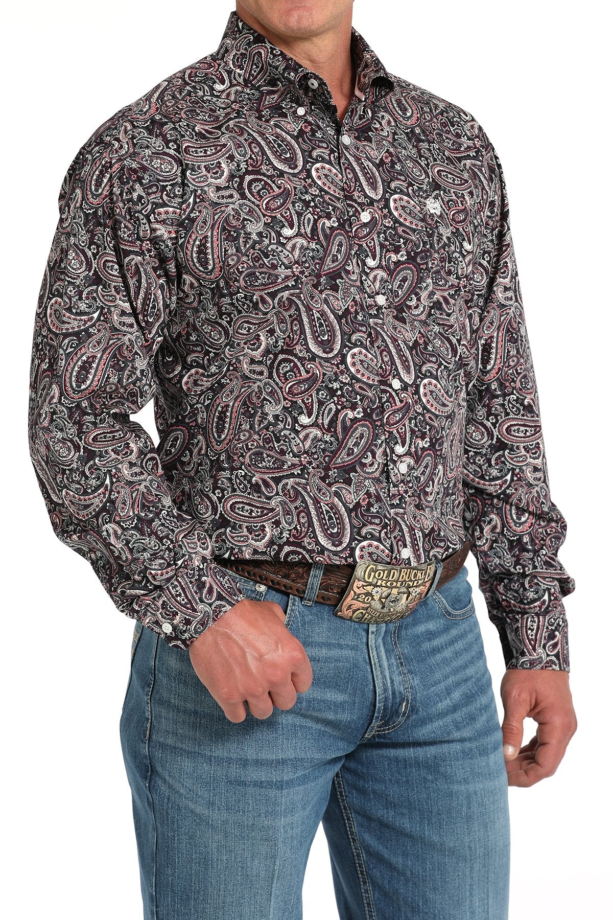 Man wearing a long sleeve button-down with a paisley pattern, paired with jeans and a belt