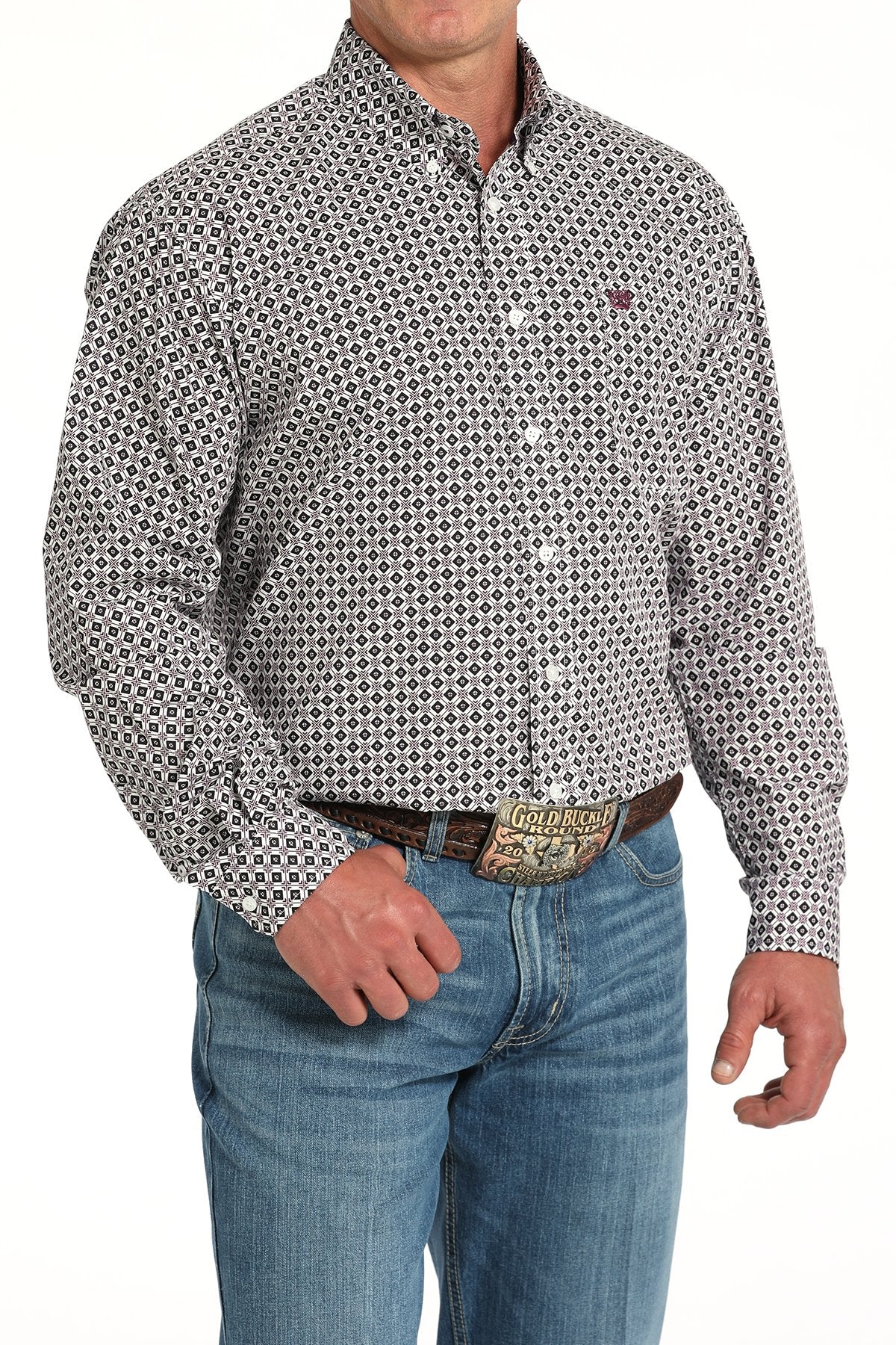 Man wearing a long sleeve button-down with a geometric pattern, paired with jeans and a belt